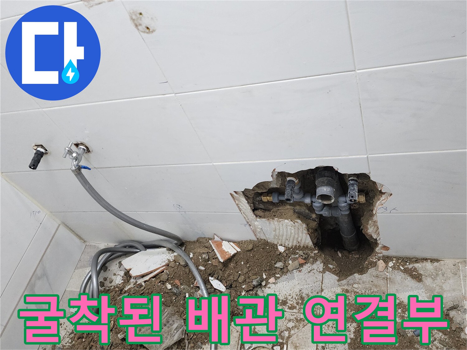 벽면 타일을 제거하여 노출시킨 하수 배관 및 주변 흙과 잔해물