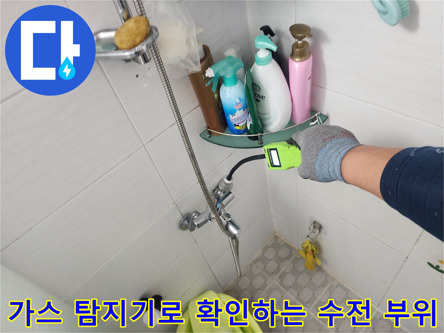욕실 수전 근처에서 가스 탐지기를 사용하여 배관 상태를 점검하는 모습입니다.