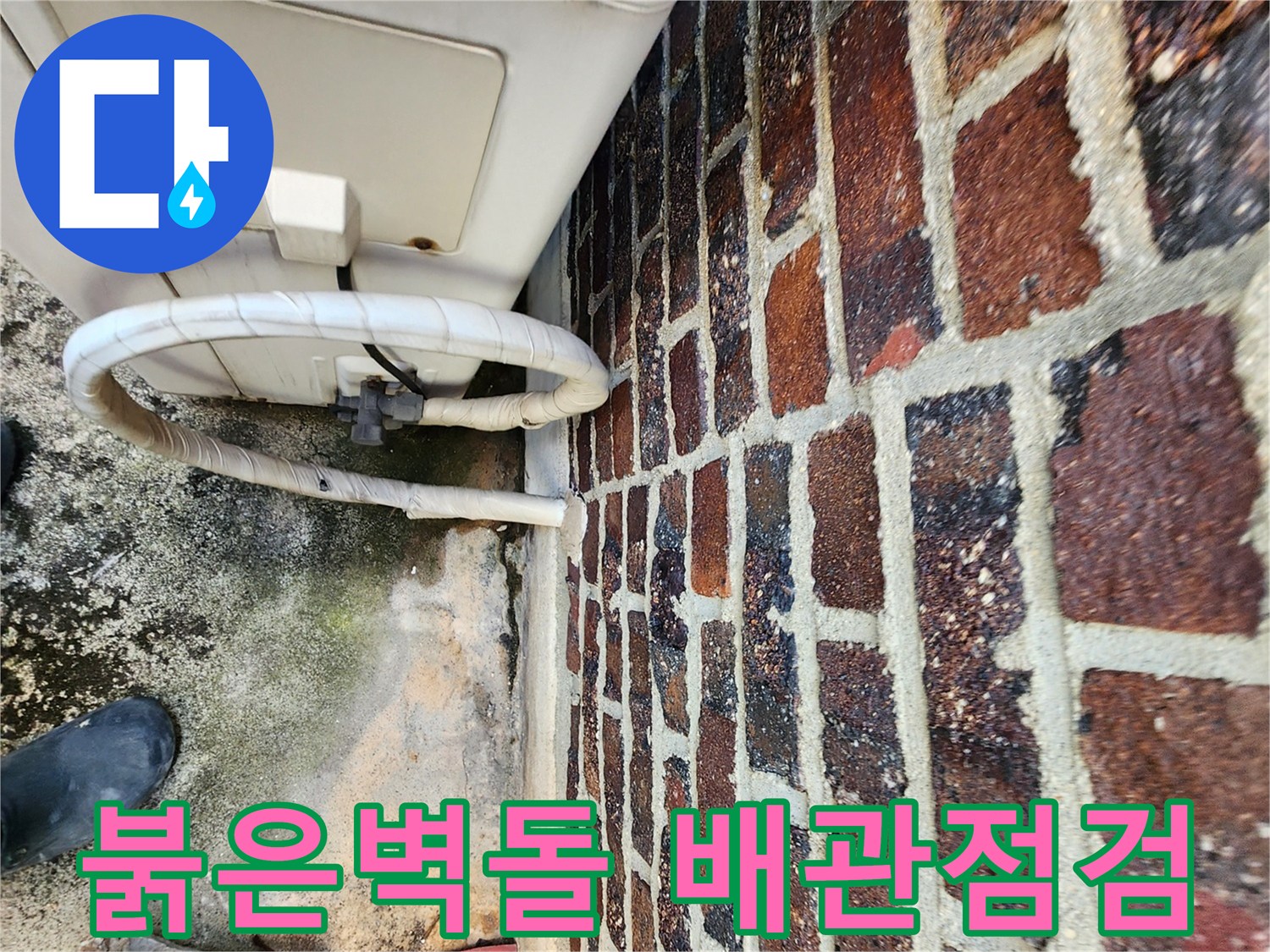 붉은색 벽돌 외벽과 에어컨 배관 연결 부위 모습