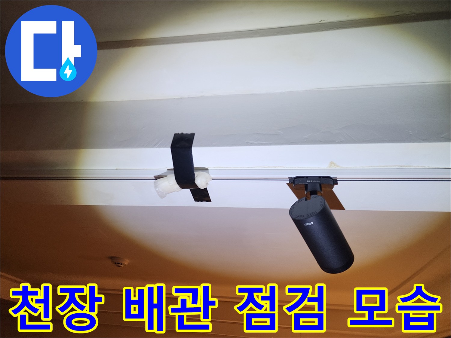 천장 구조물 사이에 설치된 검은색 배관 부품과 장비 확인