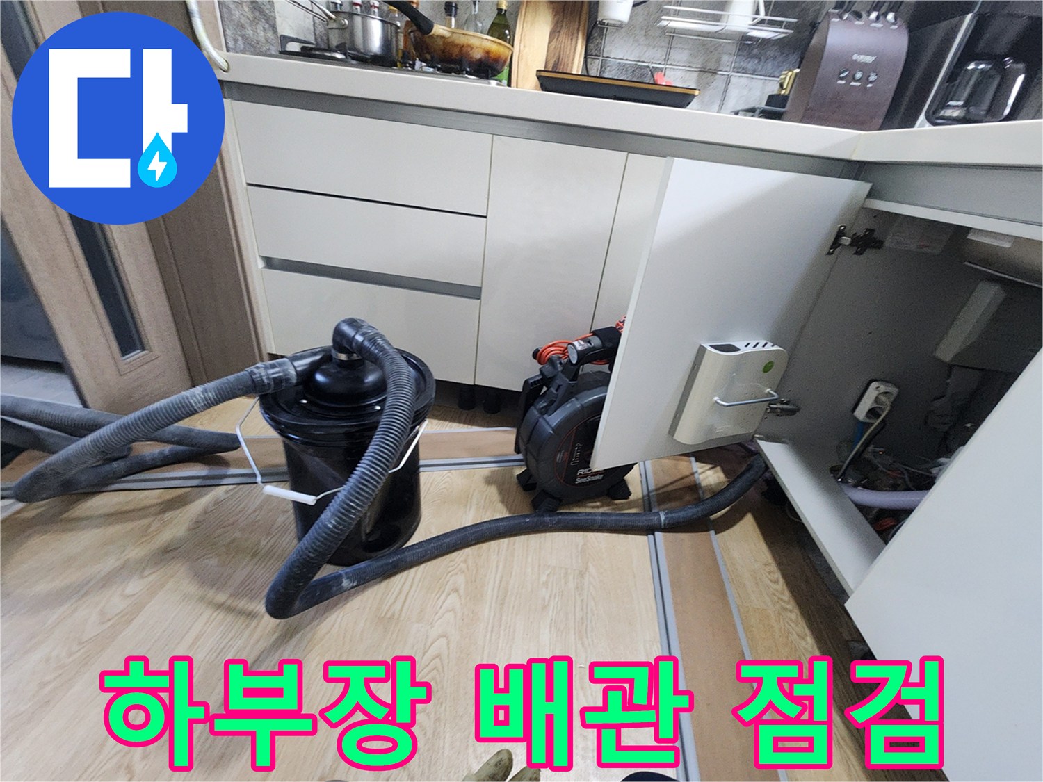싱크대 하단 가구 아래에 배치된 배관 검사용 장비입니다.