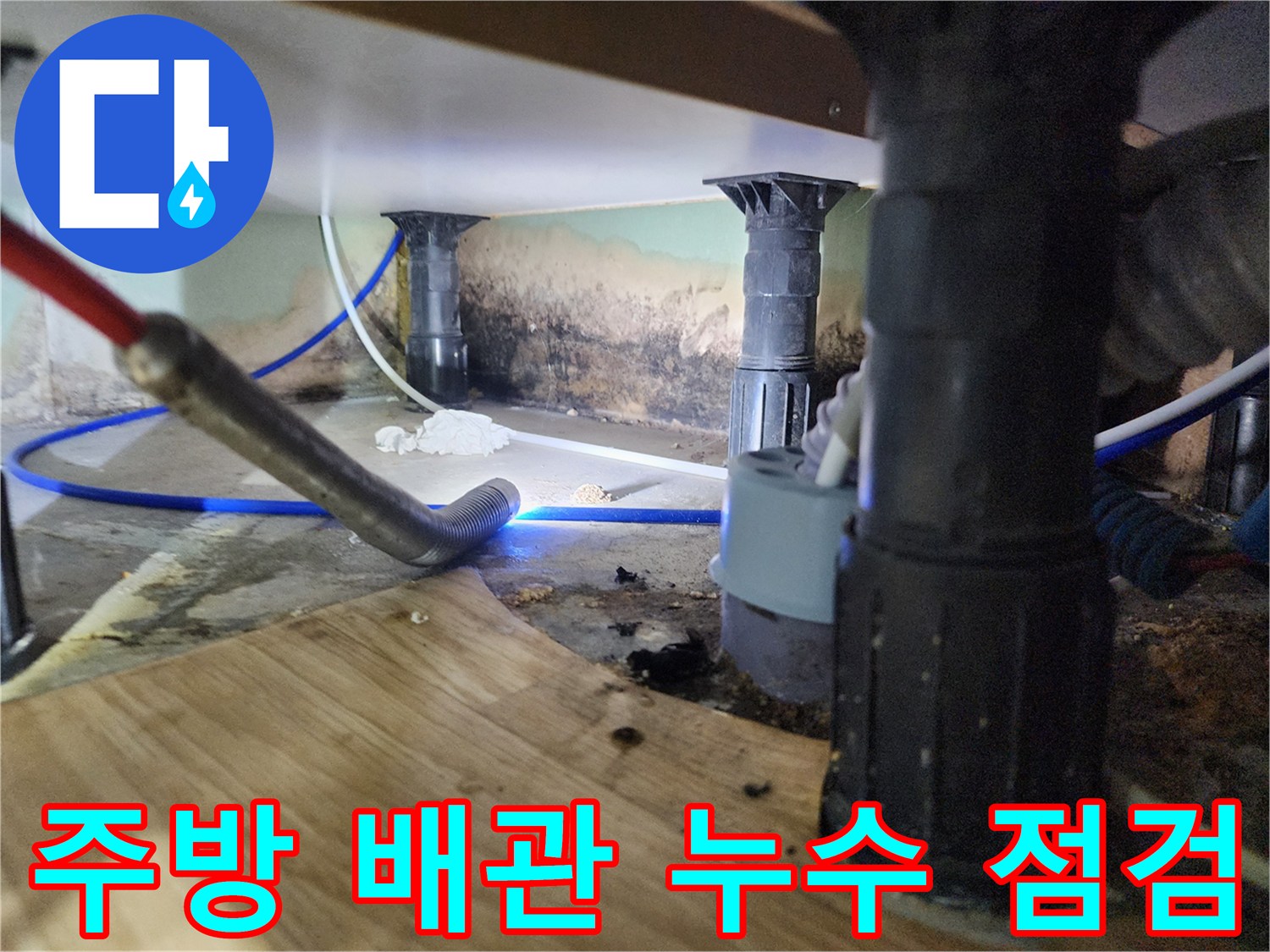 싱크대 하부 배관의 연결 부위와 주변 습기 상태를 확인하는 모습