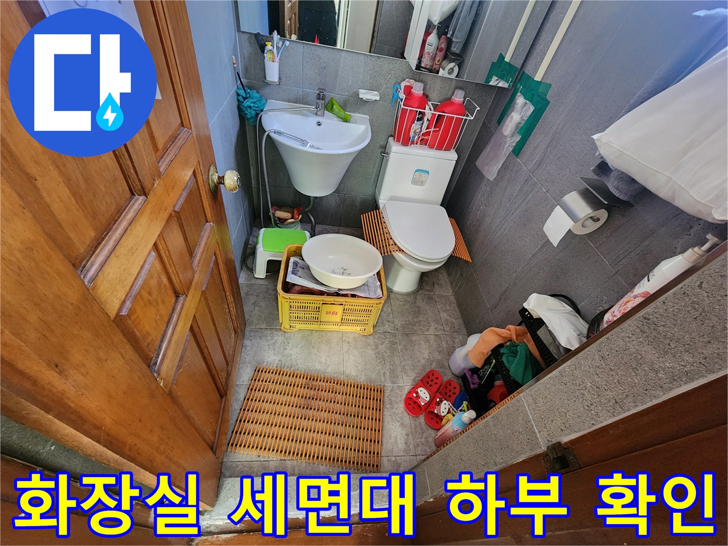 욕실 내 세면대 하단 배관 및 주변 타일 상태를 촬영한 사진