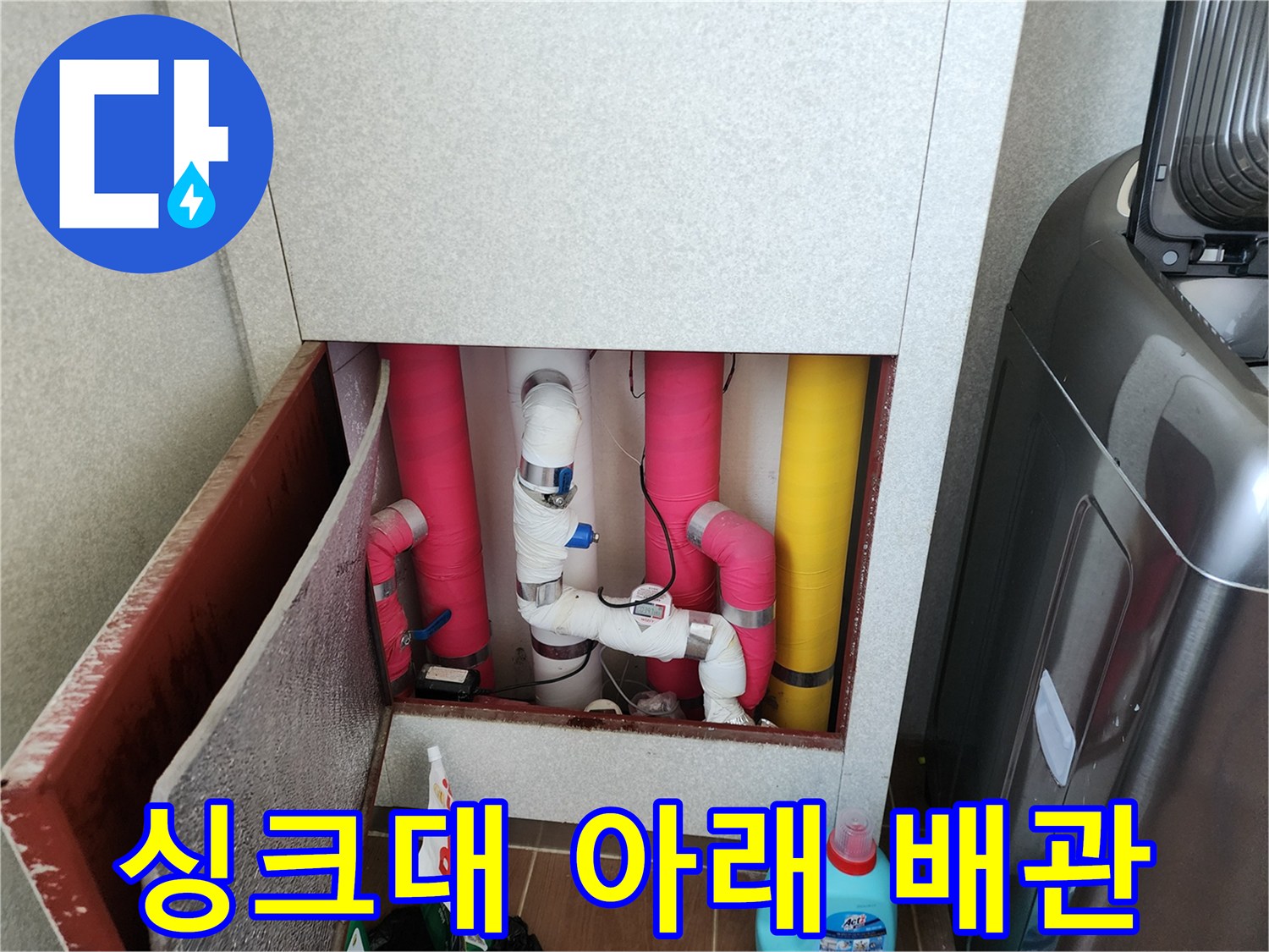 주방 싱크대 하부장 내부의 보온재로 감싸진 배관 모습