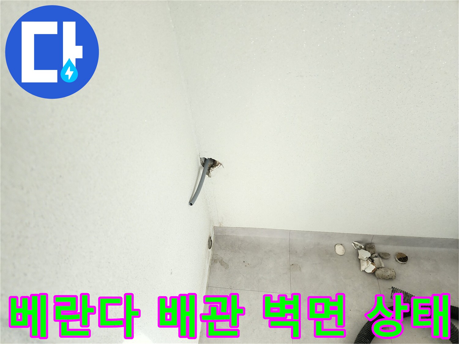 벽 하단 배관 주변의 젖은 벽면 및 타일 경계