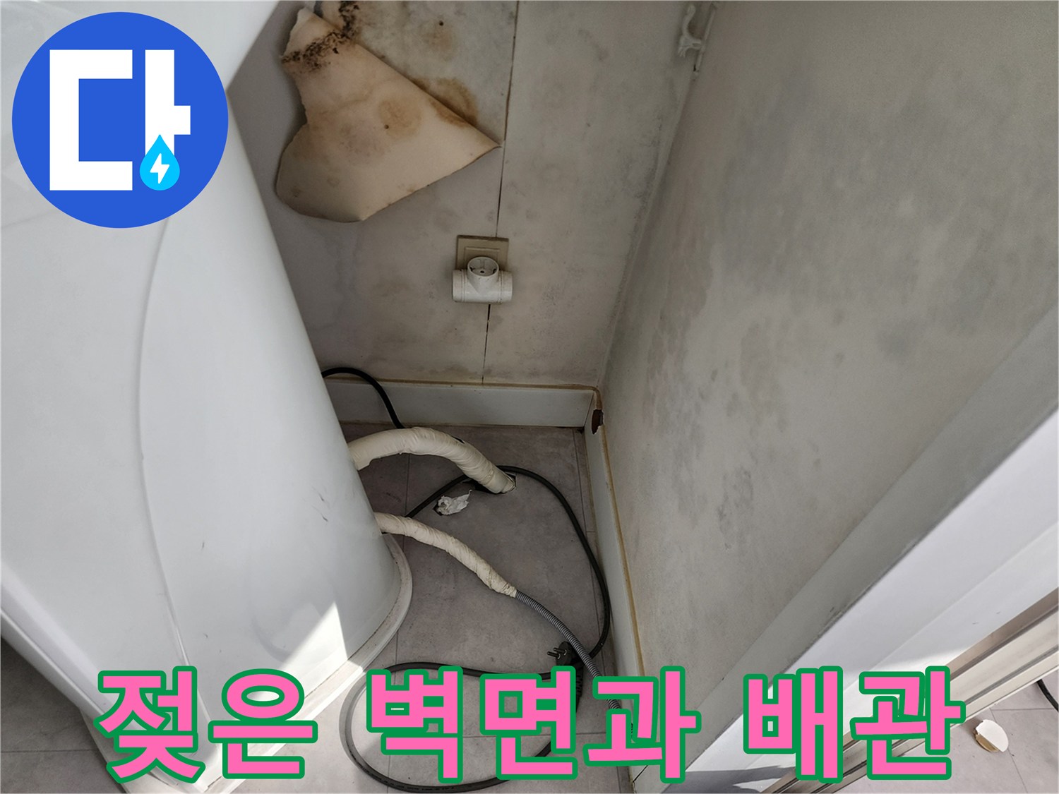 세탁실 하단부의 젖은 벽지와 노출된 배관 연결 부위