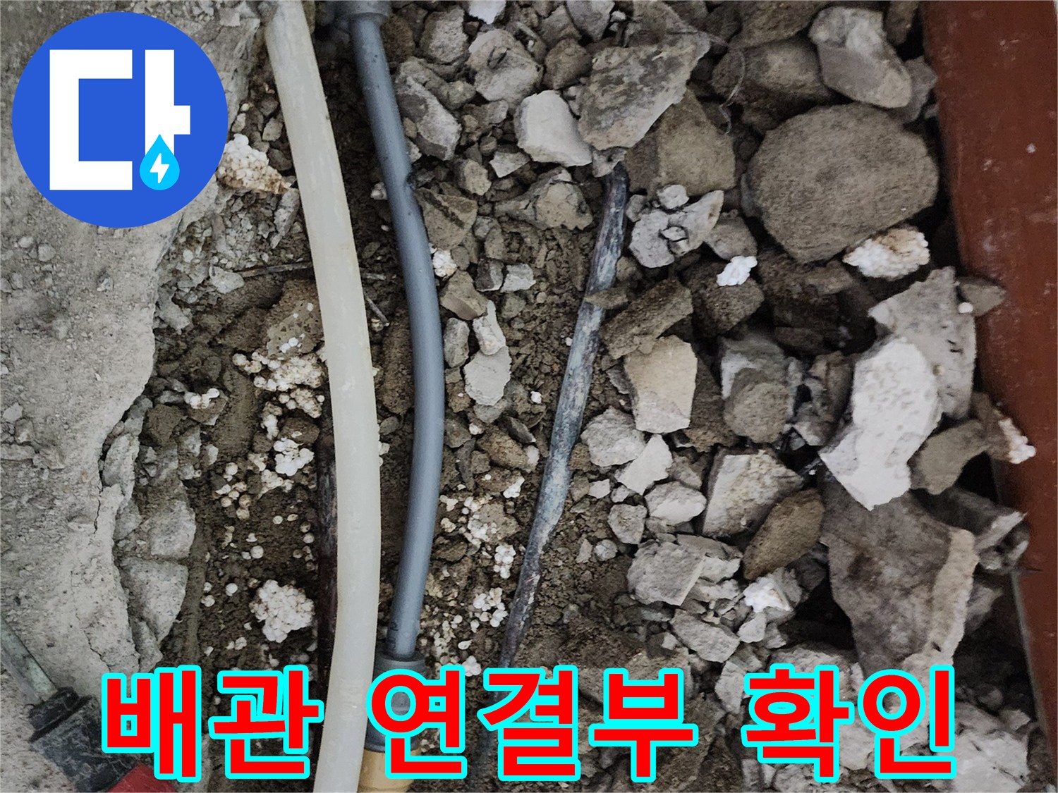 손상된 것으로 보이는 배관과 주변의 깨진 콘크리트 조각들