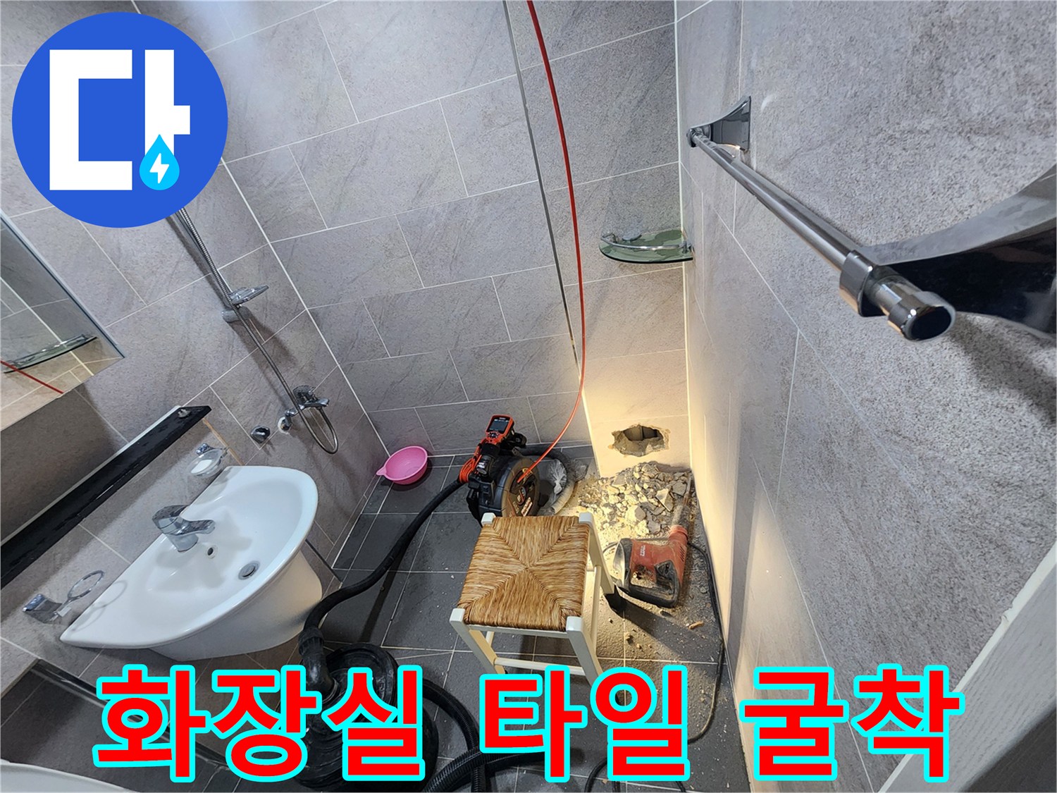 세면대 근처 타일을 제거하여 노출된 바닥 배관 작업 공간