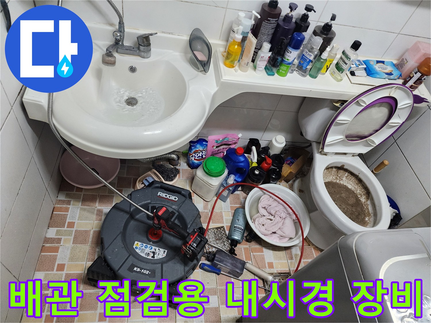욕실 세면대 아래 배치된 배관 내부 촬영을 위한 내시경 카메라와 청소 도구