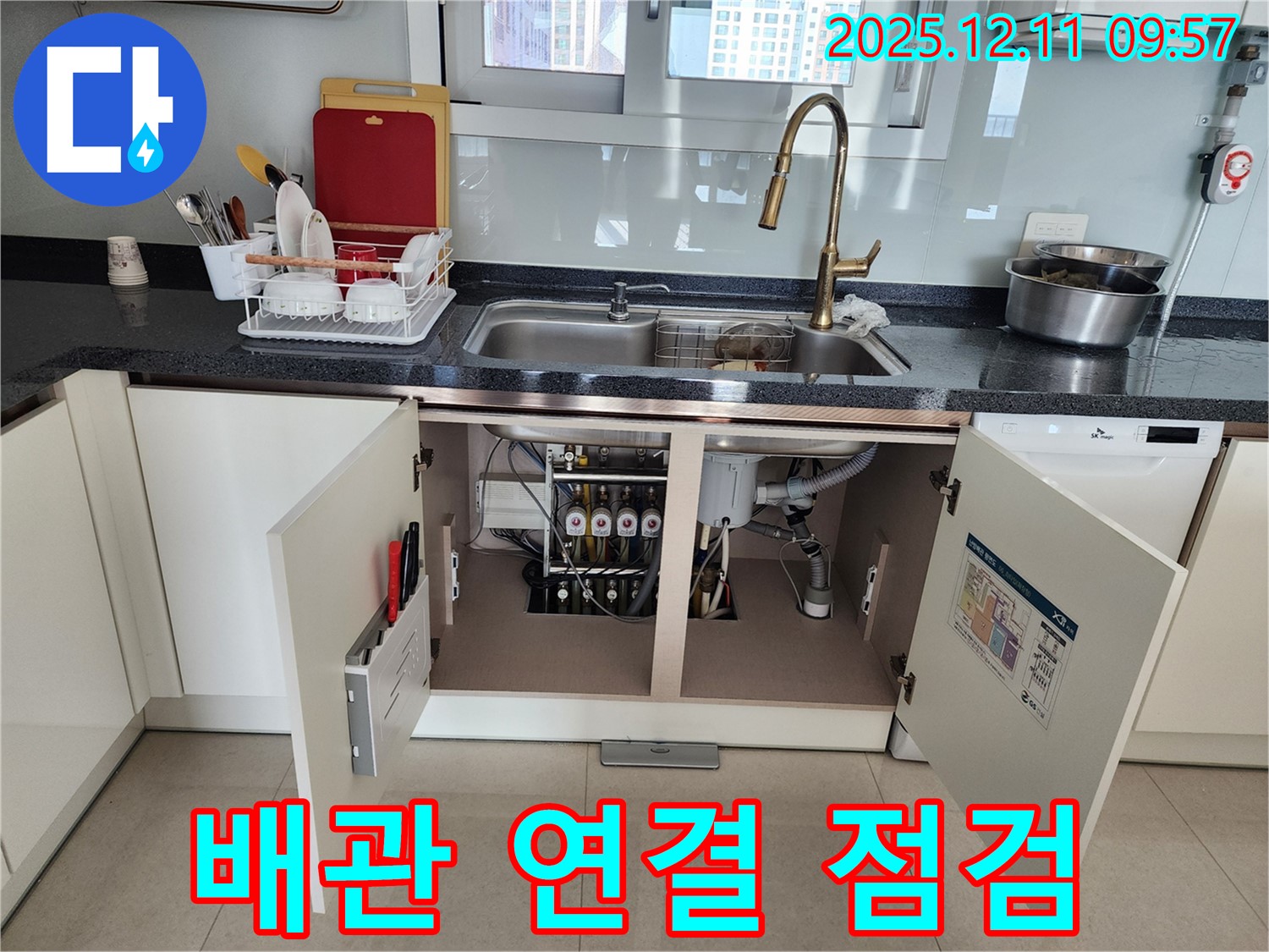 싱크대 하부 배관 연결 부위를 꼼꼼하게 집중적으로 점검하고 있습니다.