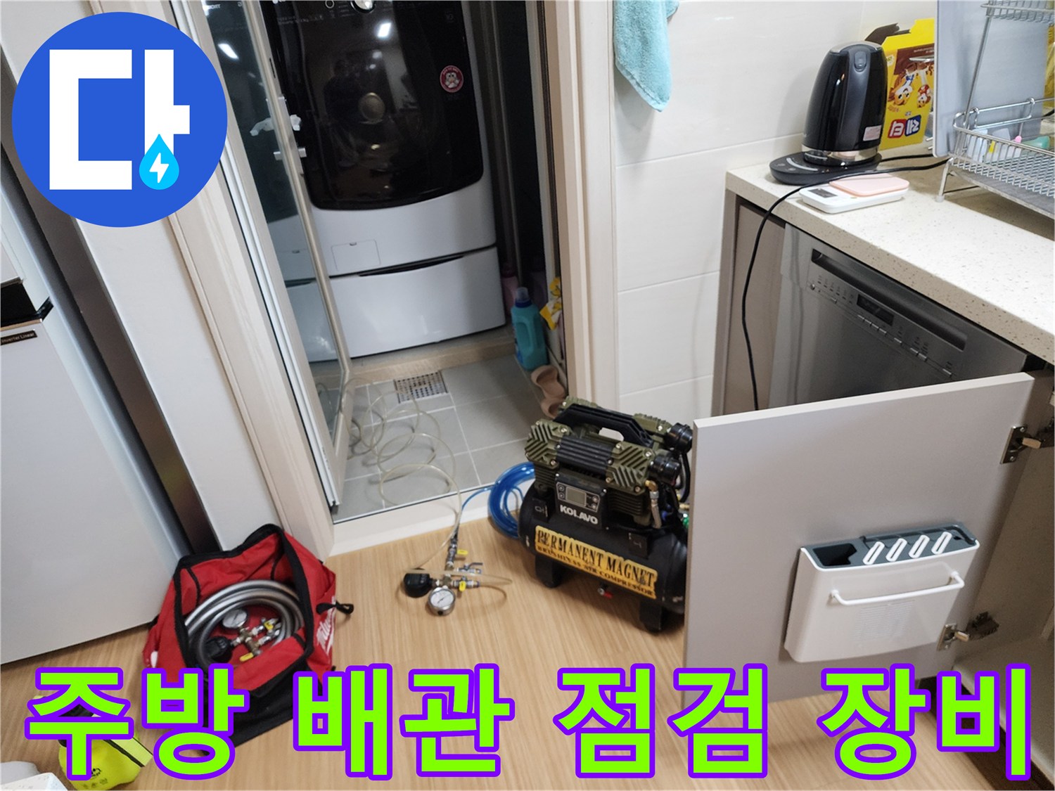주방 싱크대 하부장에서 배관 상태를 확인하기 위해 준비된 컴프레셔와 전문 장비들입니다.