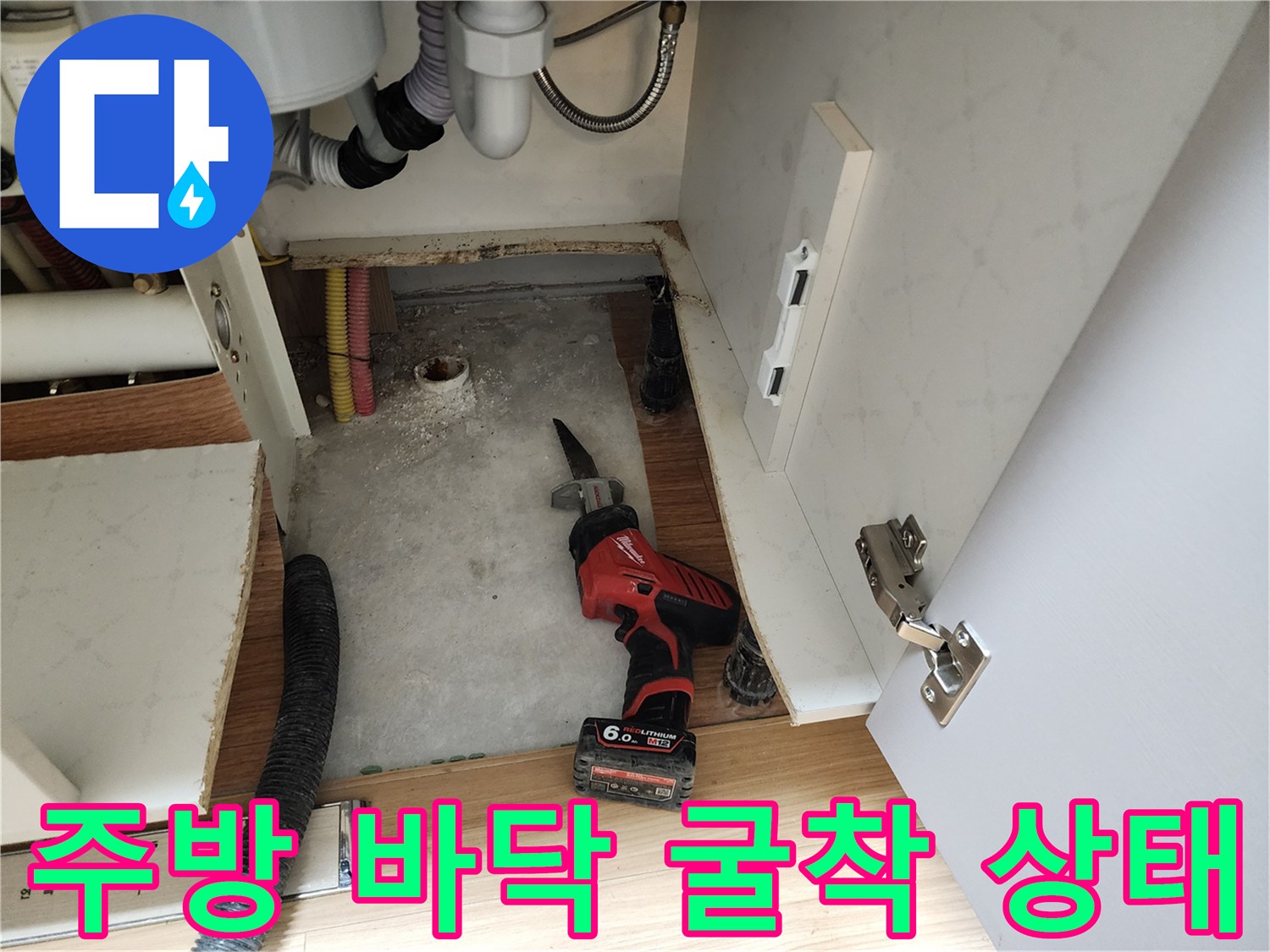싱크대 하단 굴착 후 드러난 배관과 작업 도구 - 누수 부위 확인 중