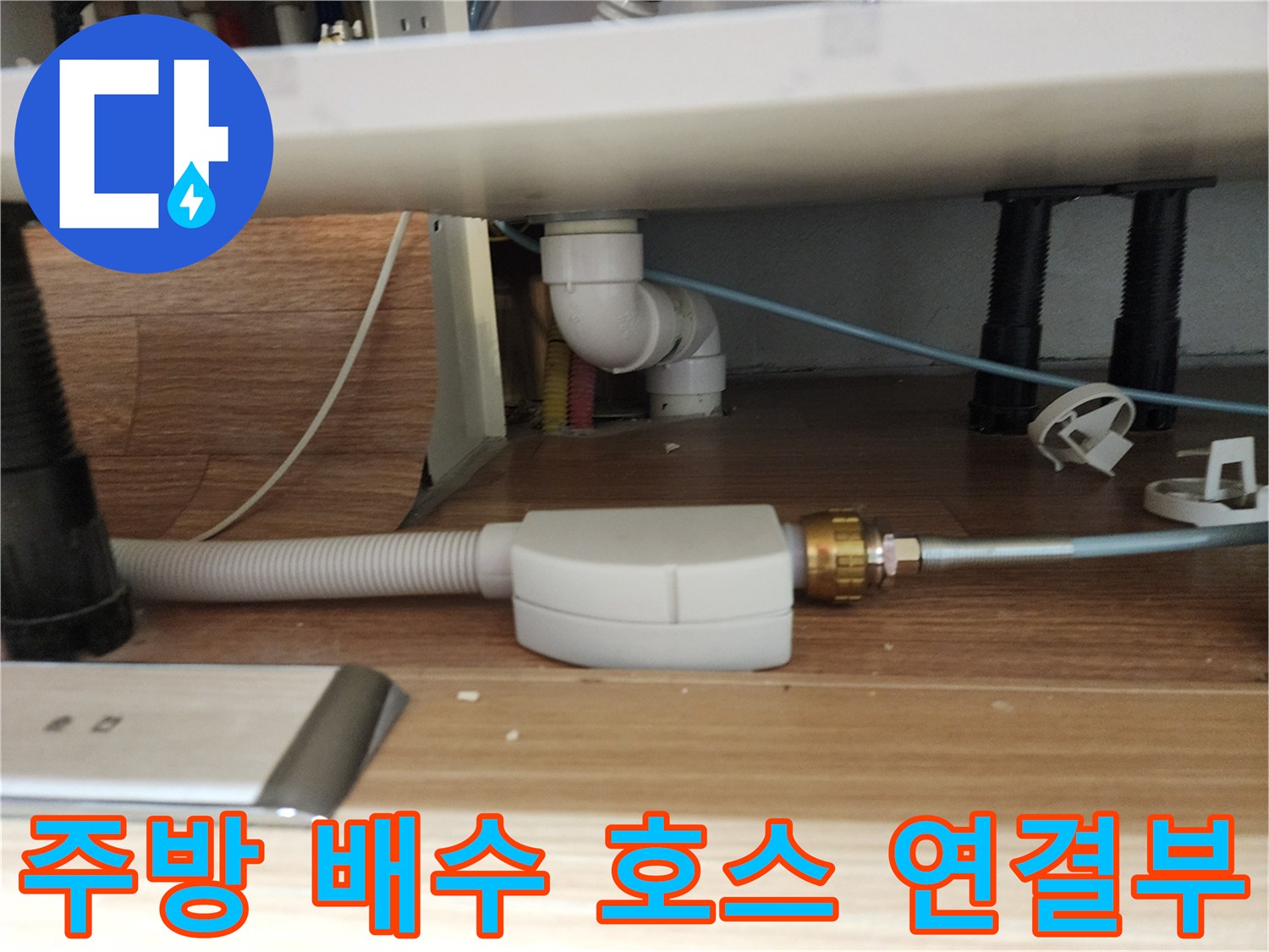 싱크대 하부의 흰색 플라스틱 배관과 주름관 상세 사진입니다.