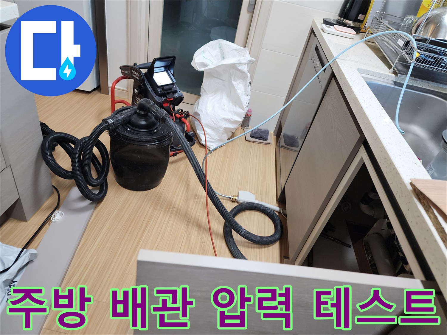 주방 싱크대 하부에서 진행 중인 배관 공압 테스트 장비 모습