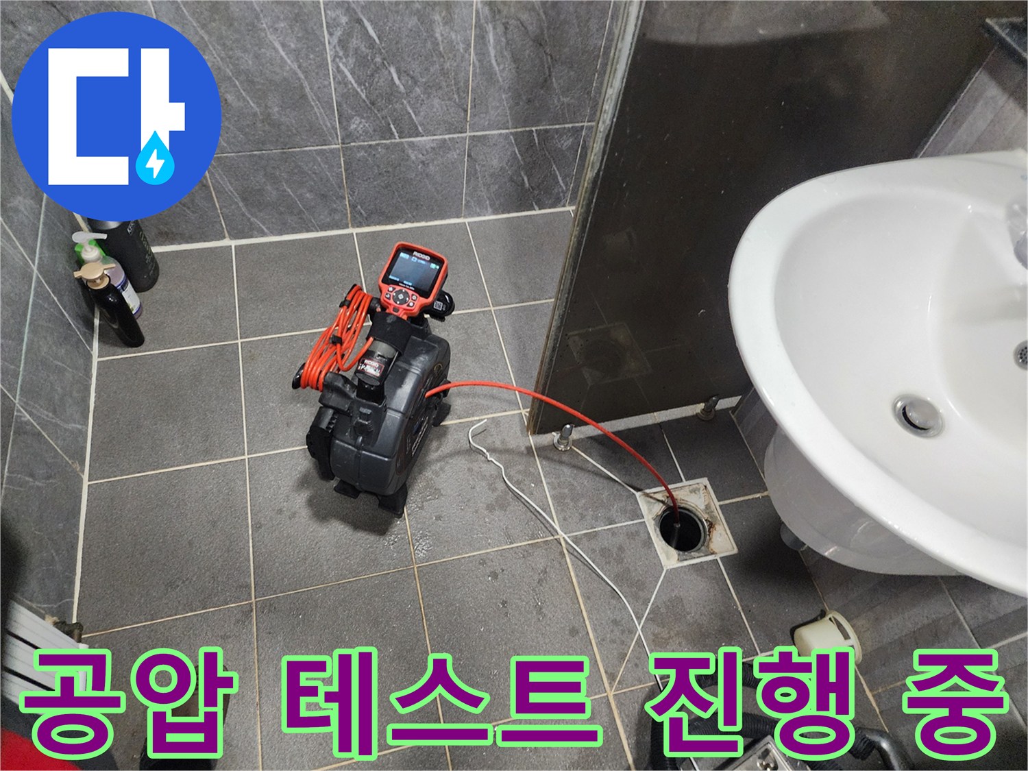 배수구 주변에서 작동 중인 배관 압력 측정 장비 세트