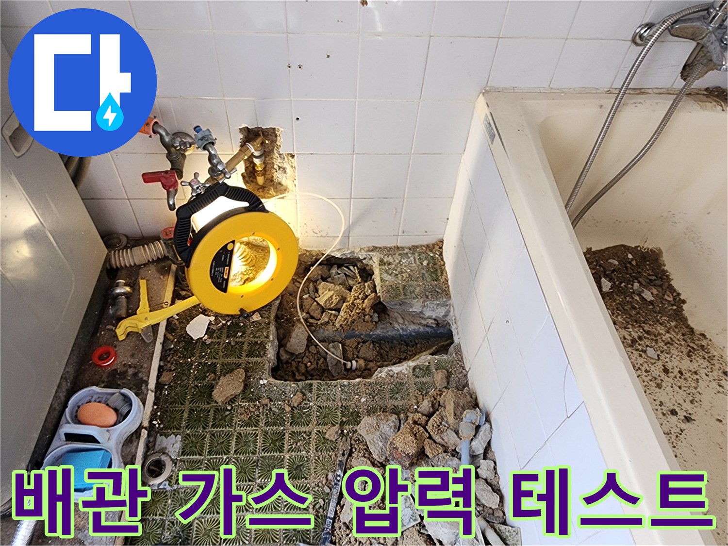 빨간색과 파란색 호스가 연결된 배관 압력 점검 장비와 굴착 부위