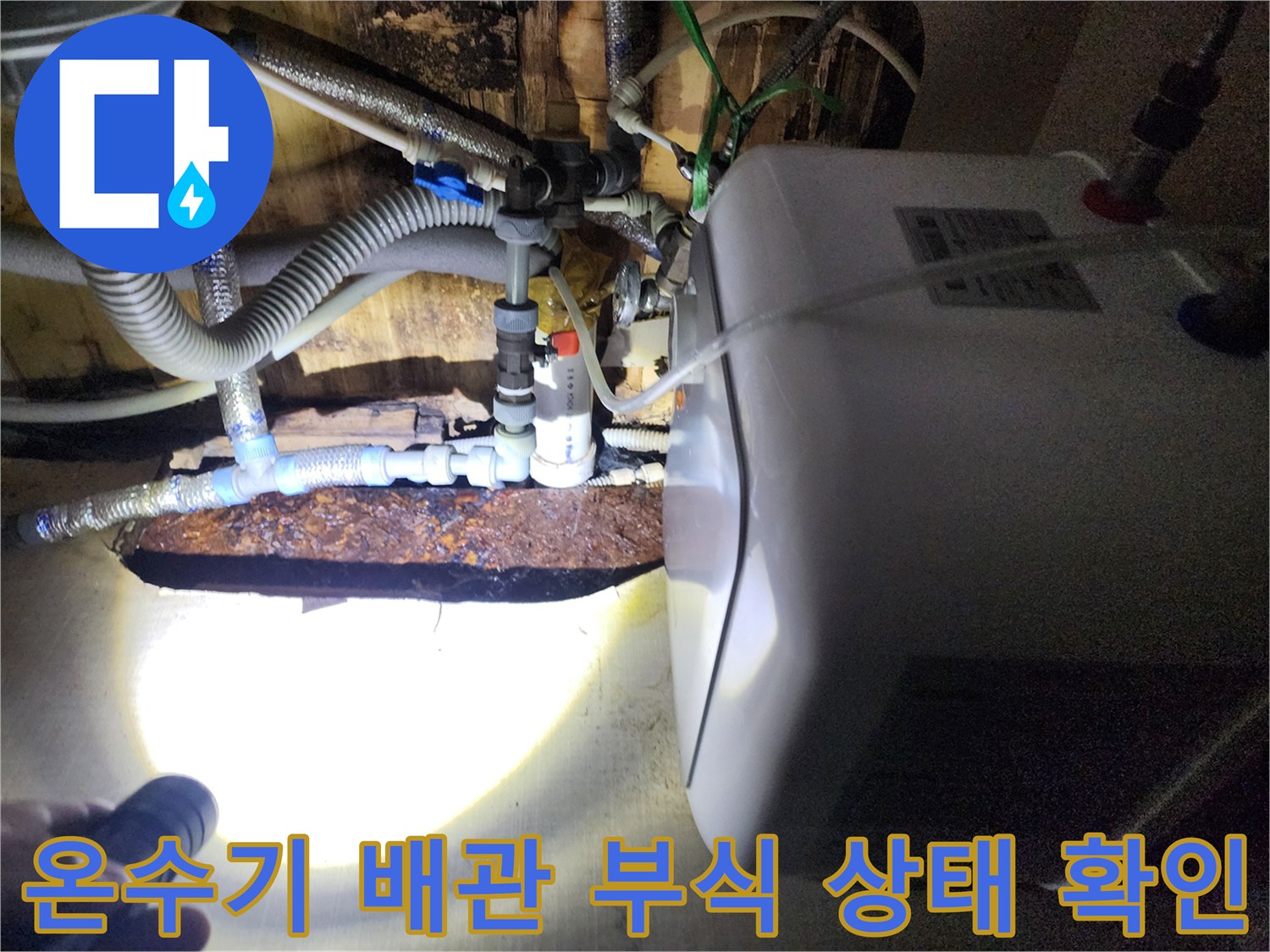 부식된 금속 연결 부위와 온수기 급수 호스 상세