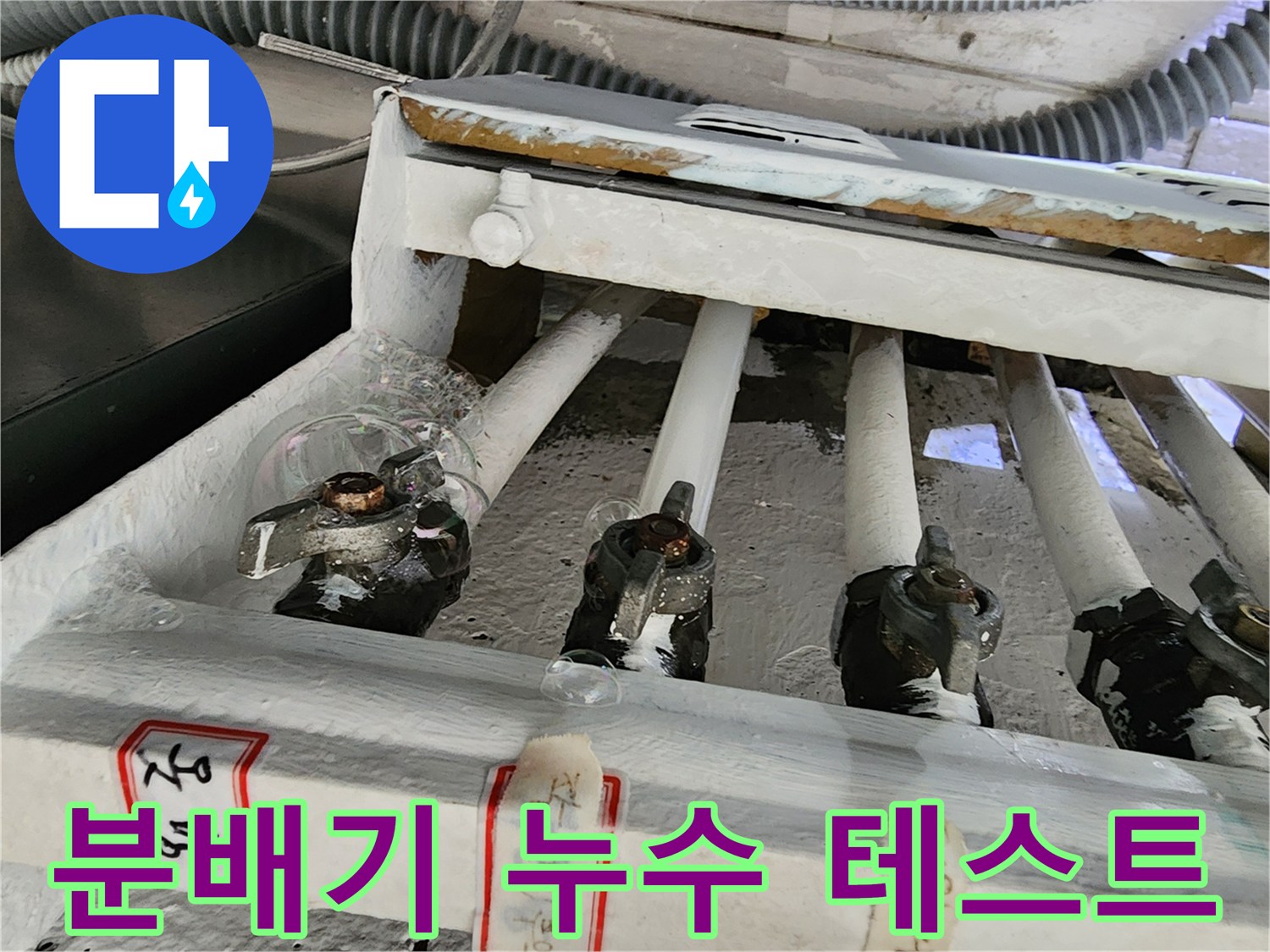 분배기 배관 연결 부위에 거품을 이용한 누수 테스트를 진행하는 모습입니다.
