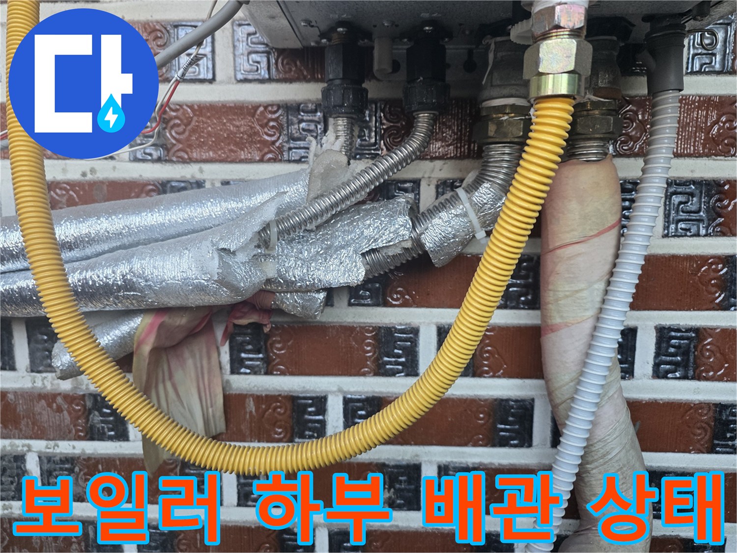 금속 부품과 은박 보온재가 씌워진 - 보일러 하단 난방 배관 상세 사진