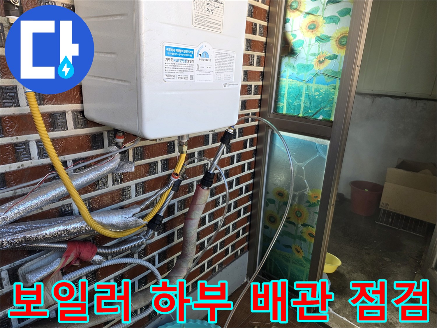 벽돌 타일 벽면에 설치된 보일러와 연결 배관의 상세 모습