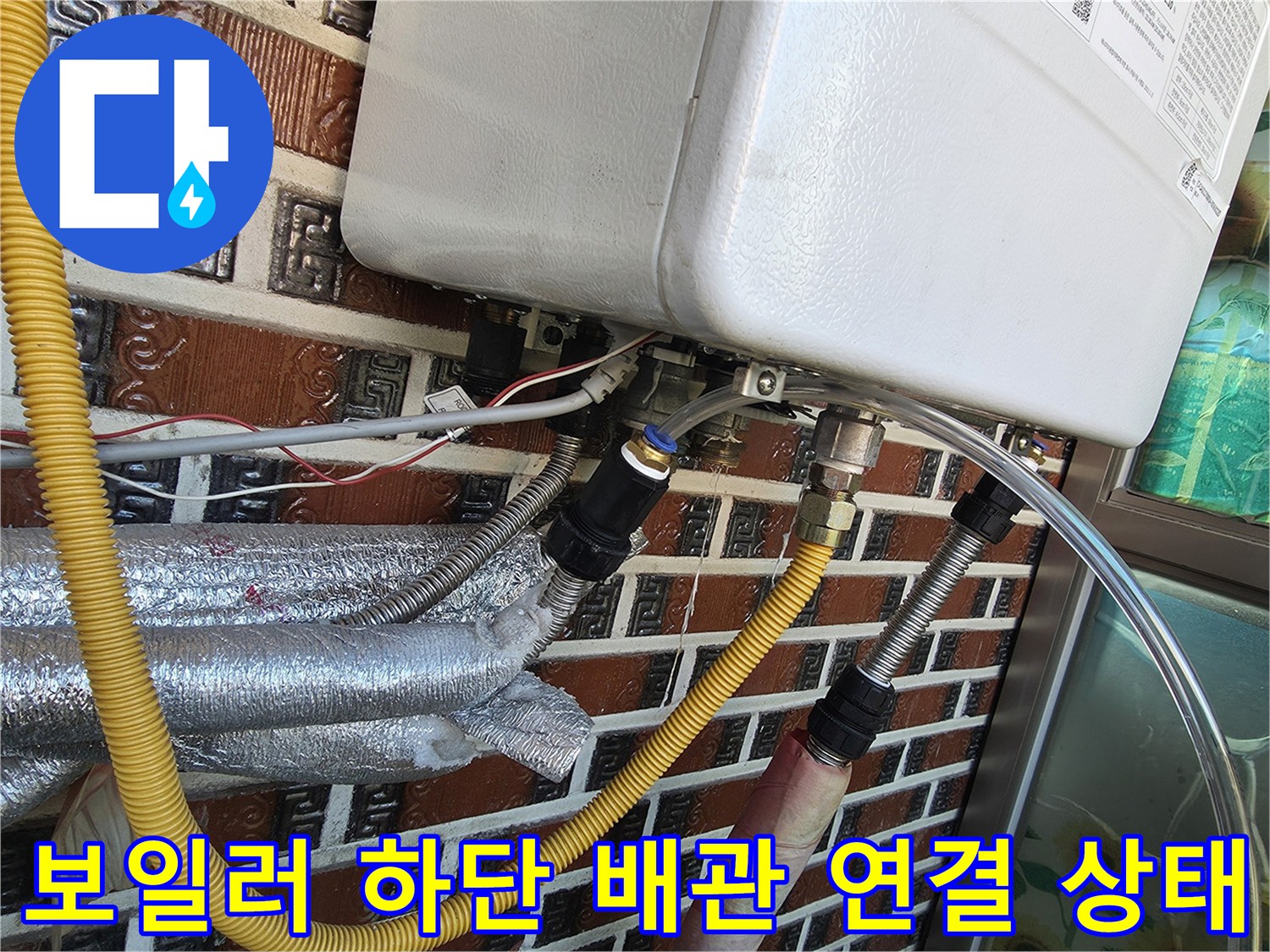 보일러 아래쪽 노란색 배관과 은색 보온재 마감된 배관 부위