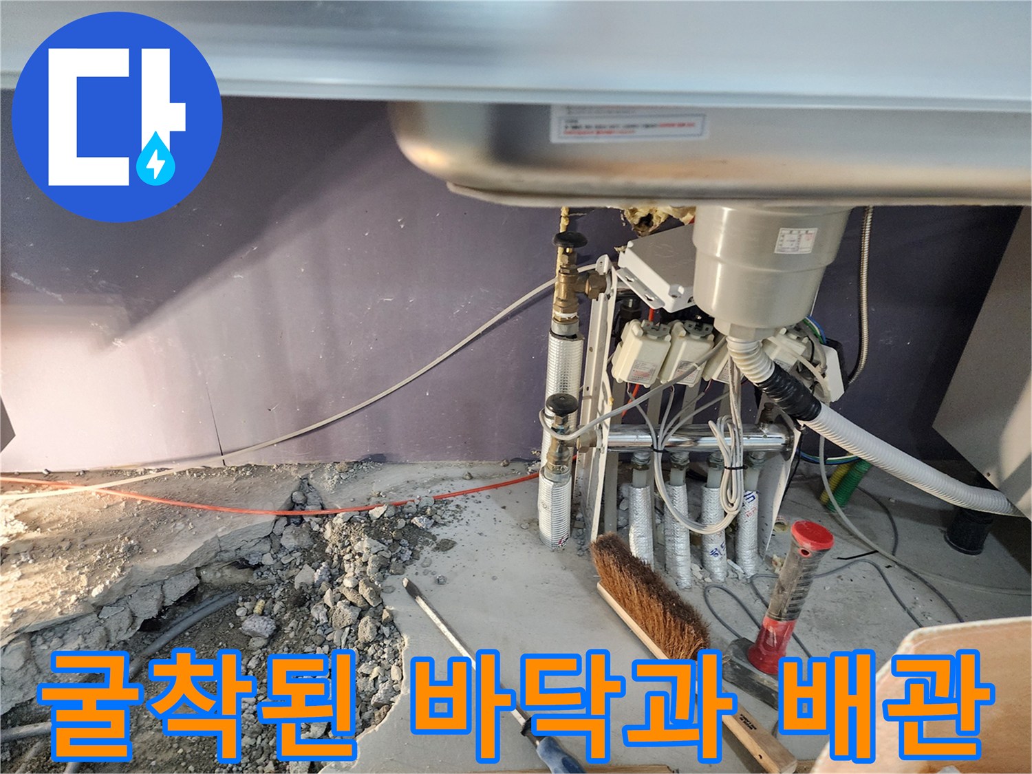 콘크리트 굴착 후 드러난 젖은 토양과 노출된 배관 연결부