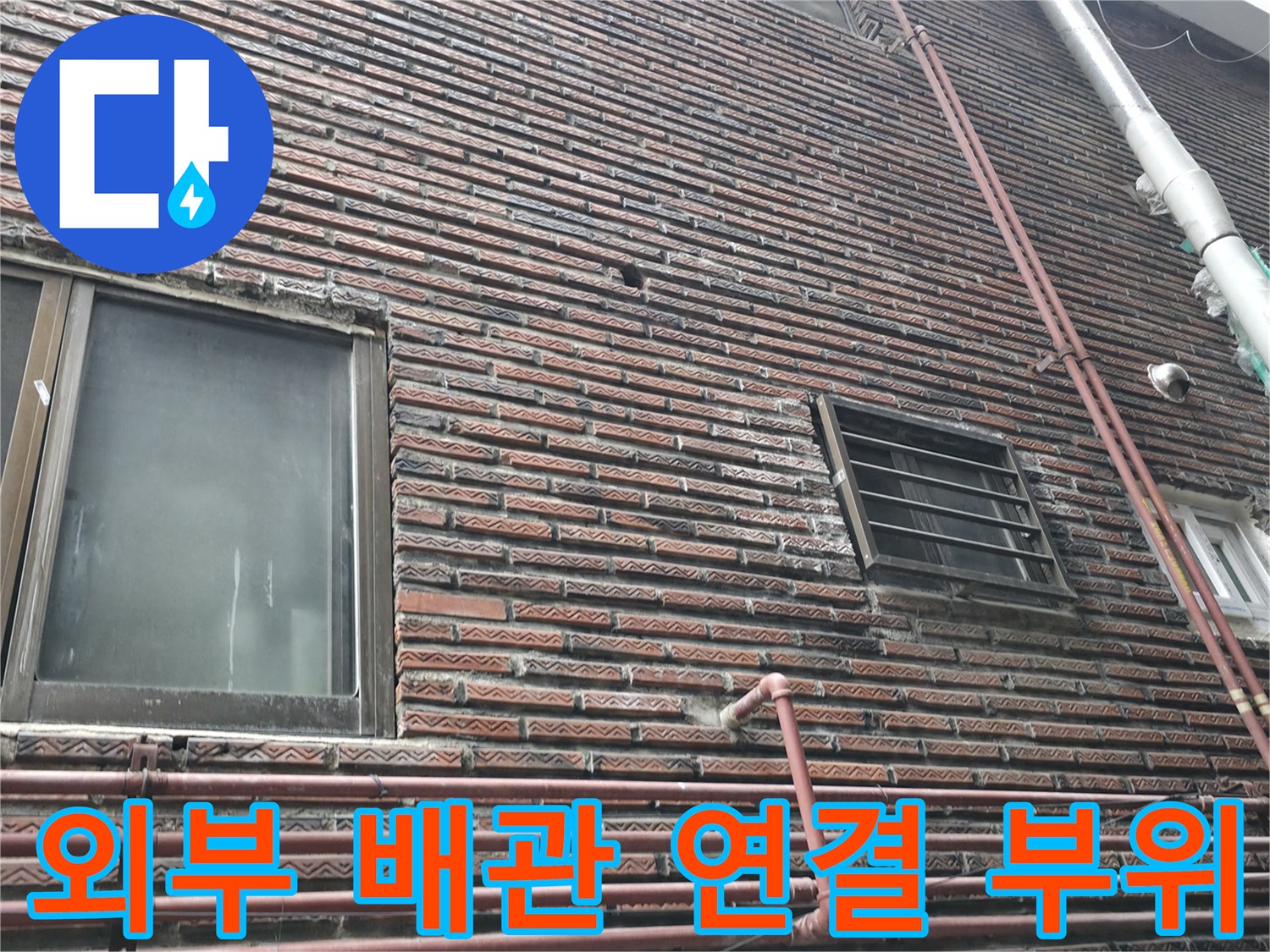 건물 외벽의 수직 배관과 창문 프레임 근처 모습
