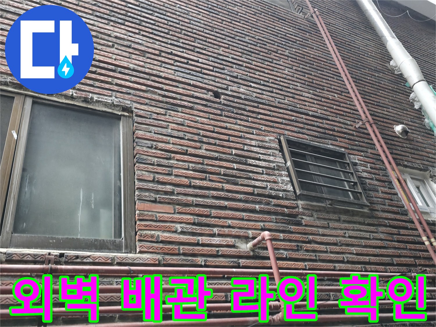 수직 및 수평으로 배치된 외벽 배관과 벽돌 마감재의 상세 모습입니다.