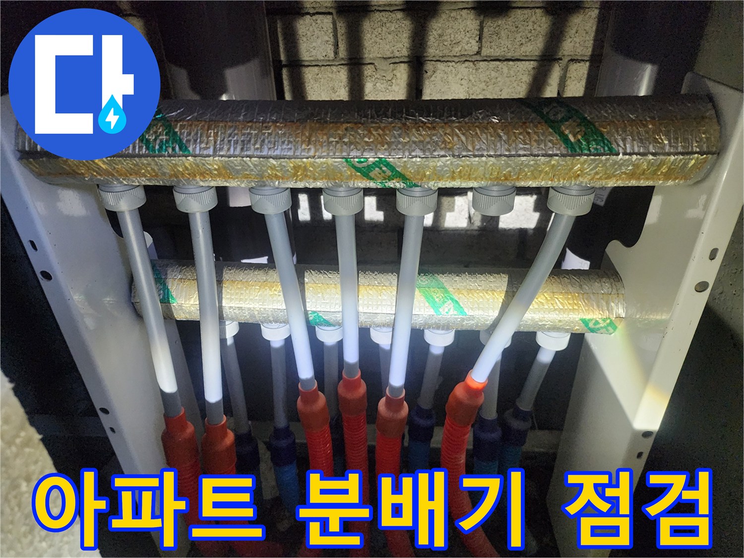 단열재로 마감된 상단 관과 연결된 하부 배관 구조