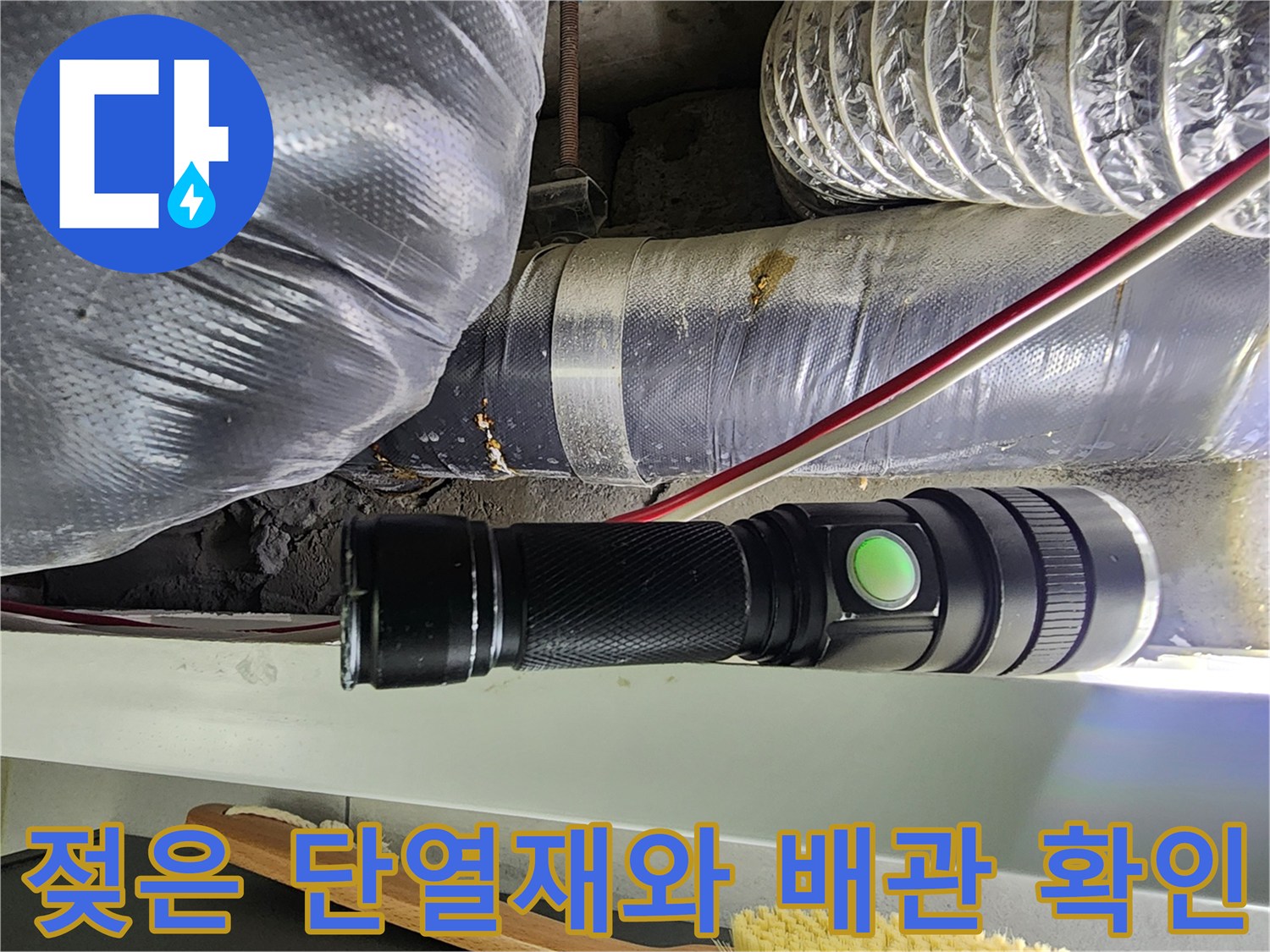 손전등으로 비춘-물기에 젖어 있는 천장 내부 배관