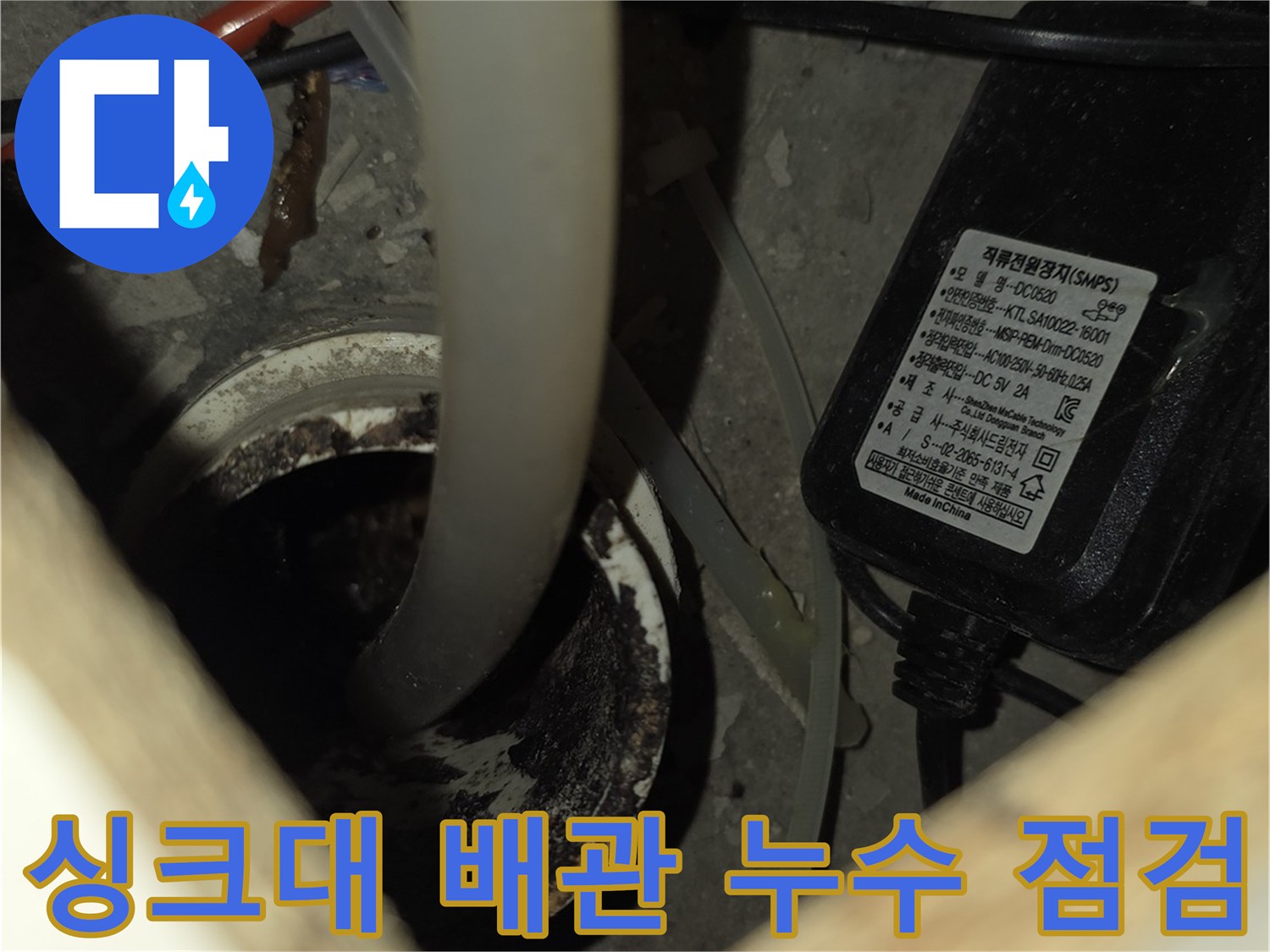 가스 탐지기를 사용하여 싱크대 하부 배관을 조사하는 모습