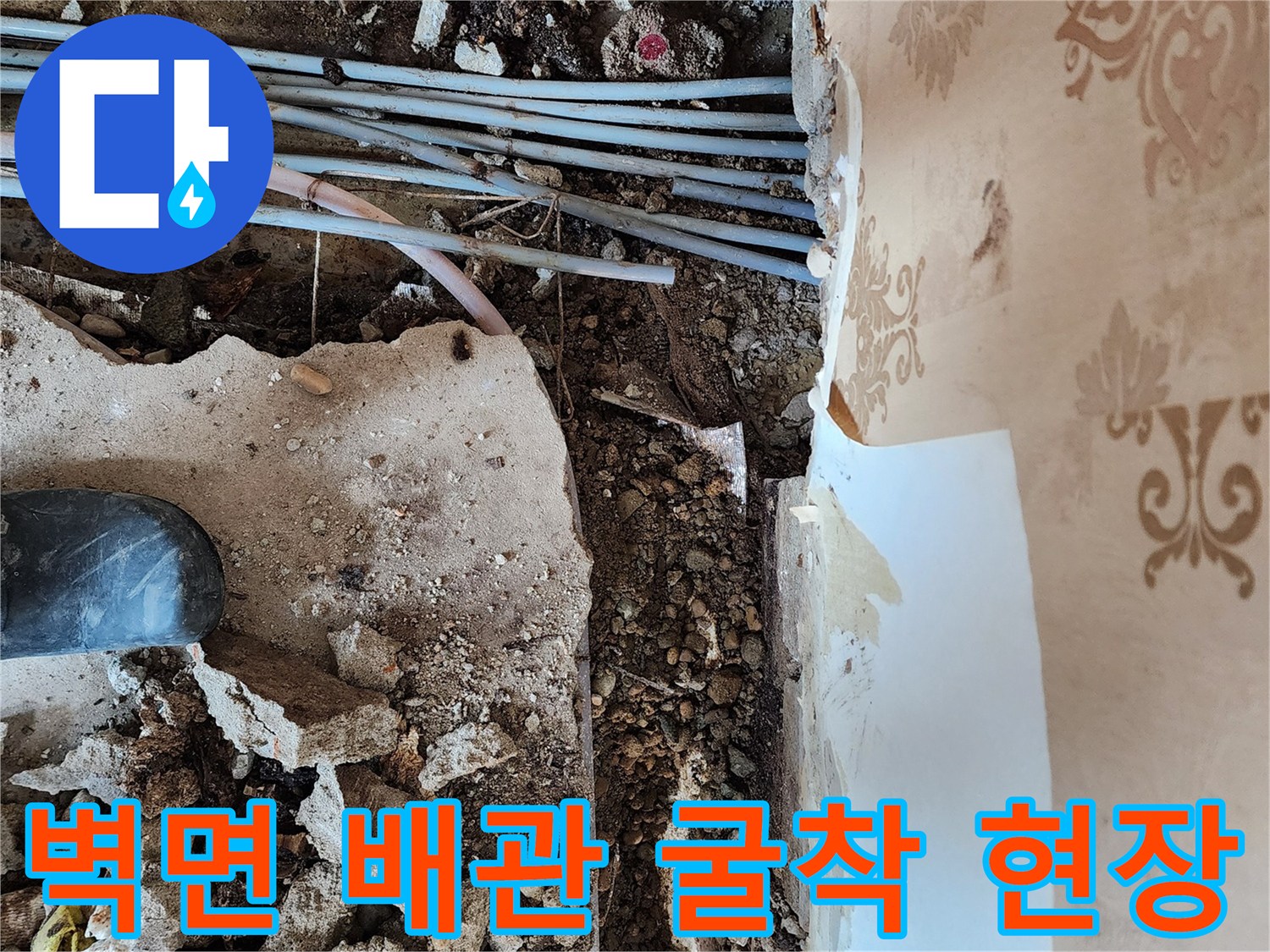 동두천 보산동 누수 공사를 위해 벽면 하단 타일을 제거하고 노출된 매립 배관 상태를 점검하는 모습입니다.