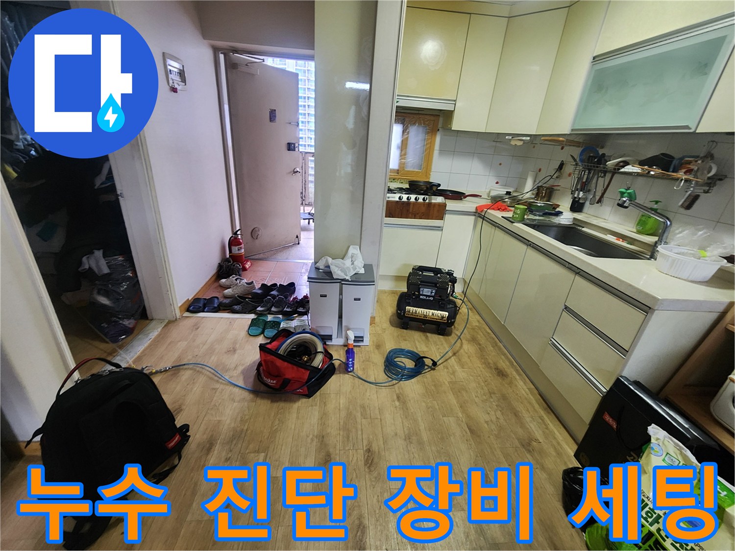 주방 바닥에 배치된 누수 탐지용 압력계와 청소용 장비들 - 고암동 현장