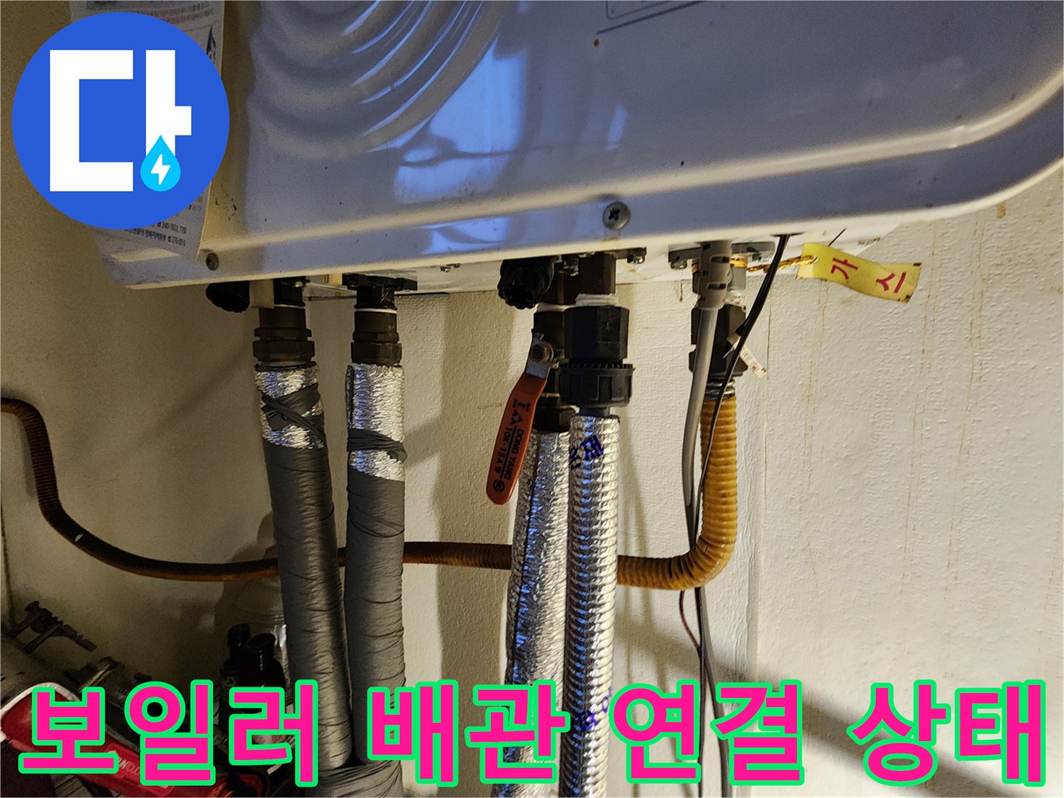 보일러 하단에 연결된 다양한 종류의 배관과 밸브 모습