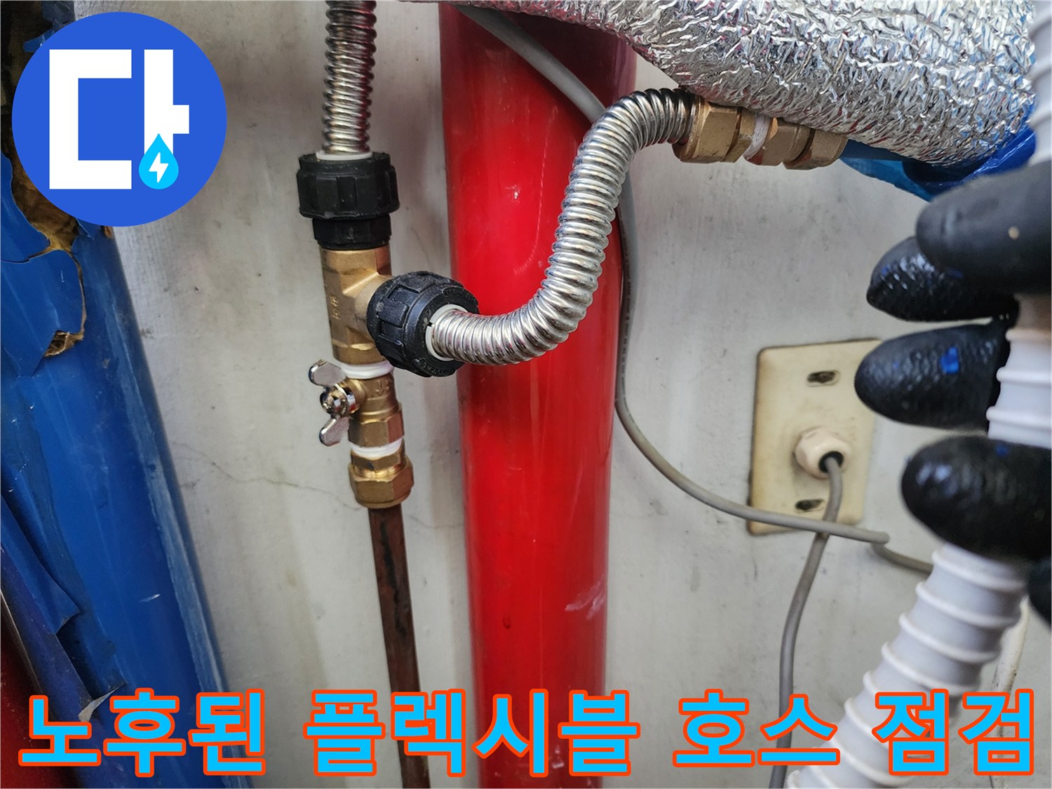 은색 굴곡진 호스와 금속 밸브가 연결된 모습