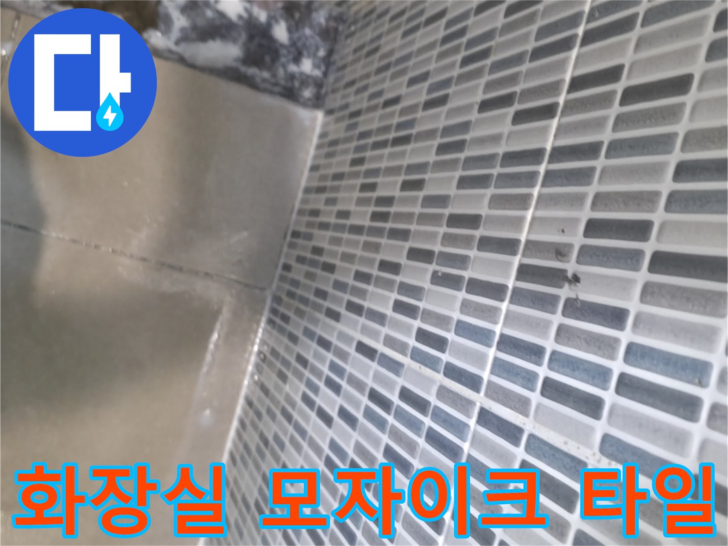 욕실 벽면의 작은 모자이크 타일과 바닥 타일 경계 부분