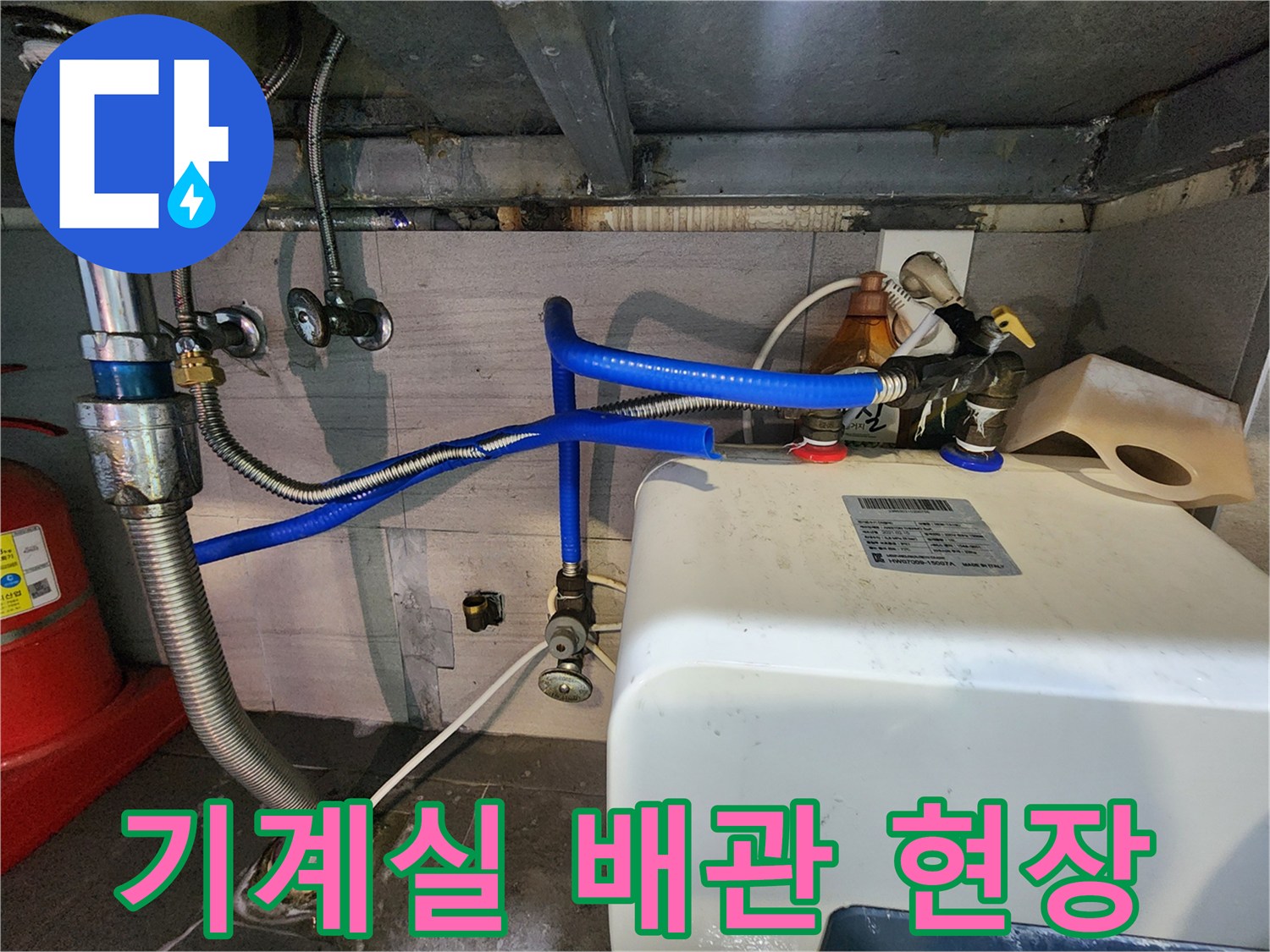 상가 지하 기계실의 파란색 호스와 배관 연결 부위 모습