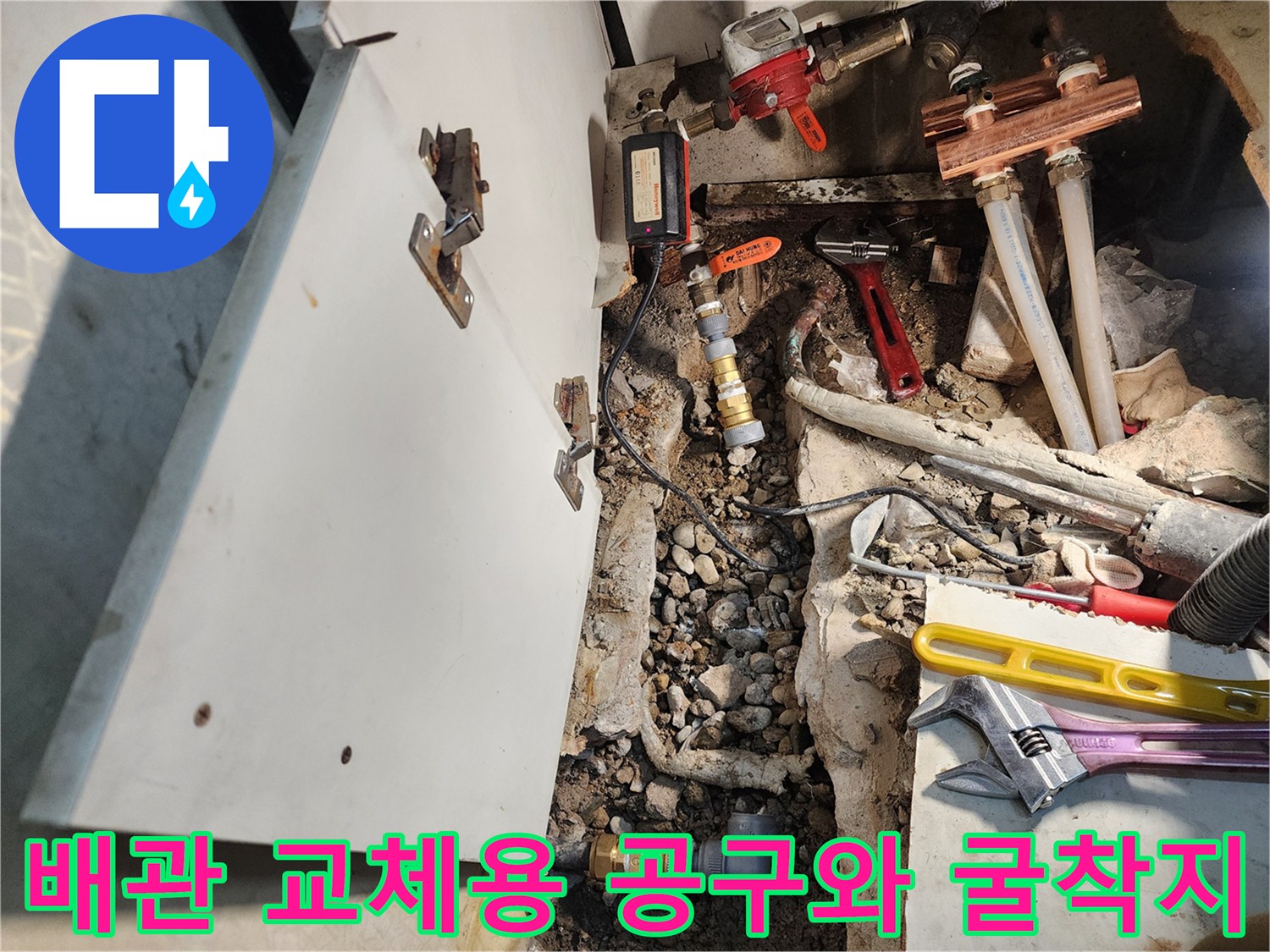 누수 지점 보수를 위해 준비된 렌치와 파헤쳐진 바닥 배관