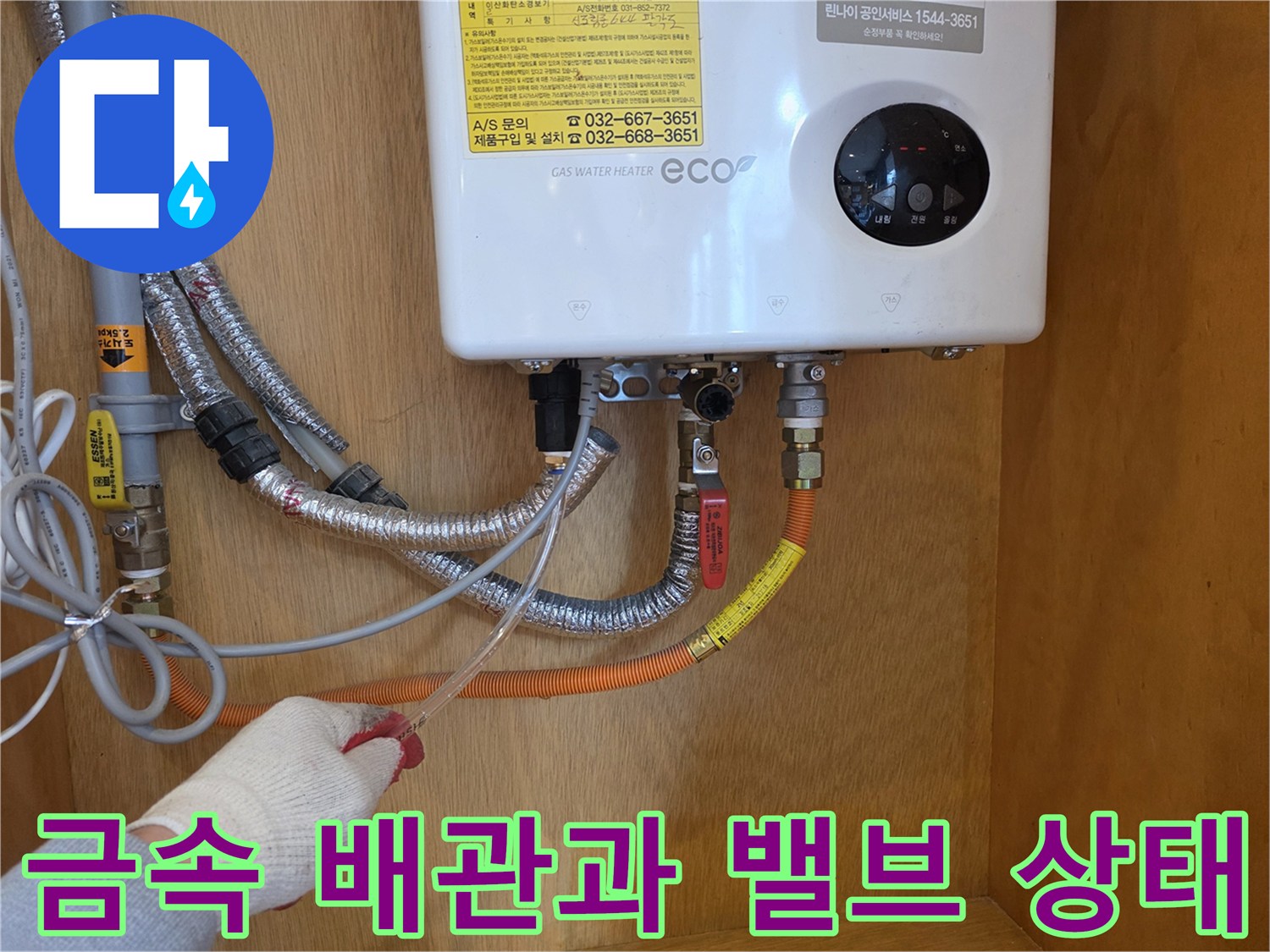 온수기 아래쪽의 금속 배관 및 제어 밸브 상세 사진