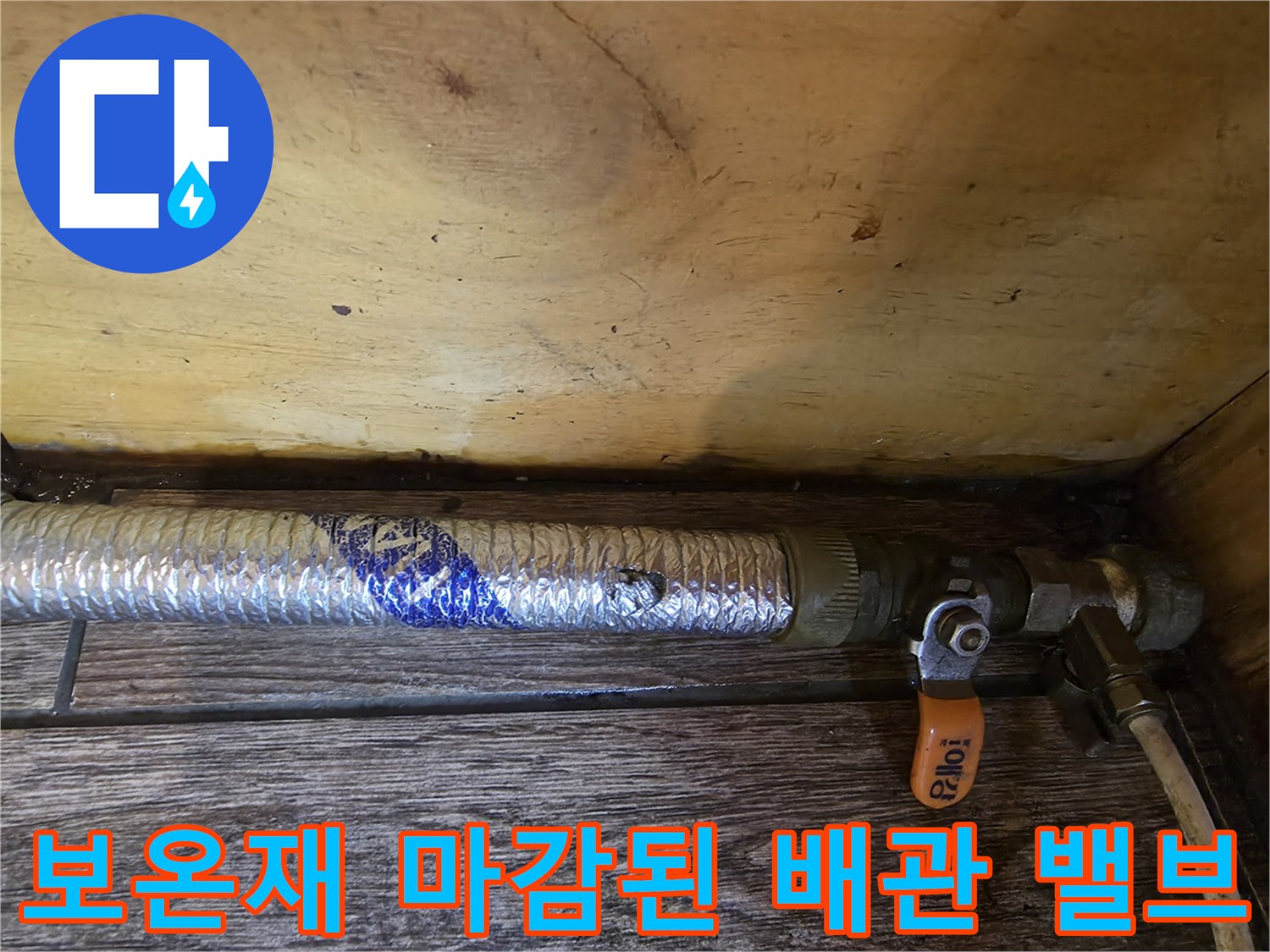 주황색 핸들이 있는 밸브와 보온재가 입혀진 배관