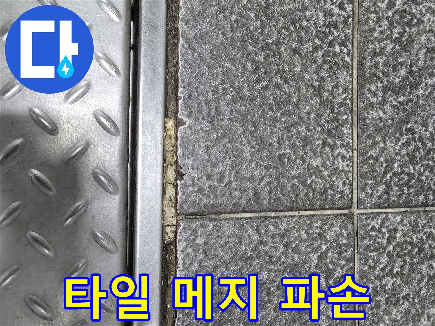 회색 타일과 스테인리스 트렌치 사이의 파손된 줄눈