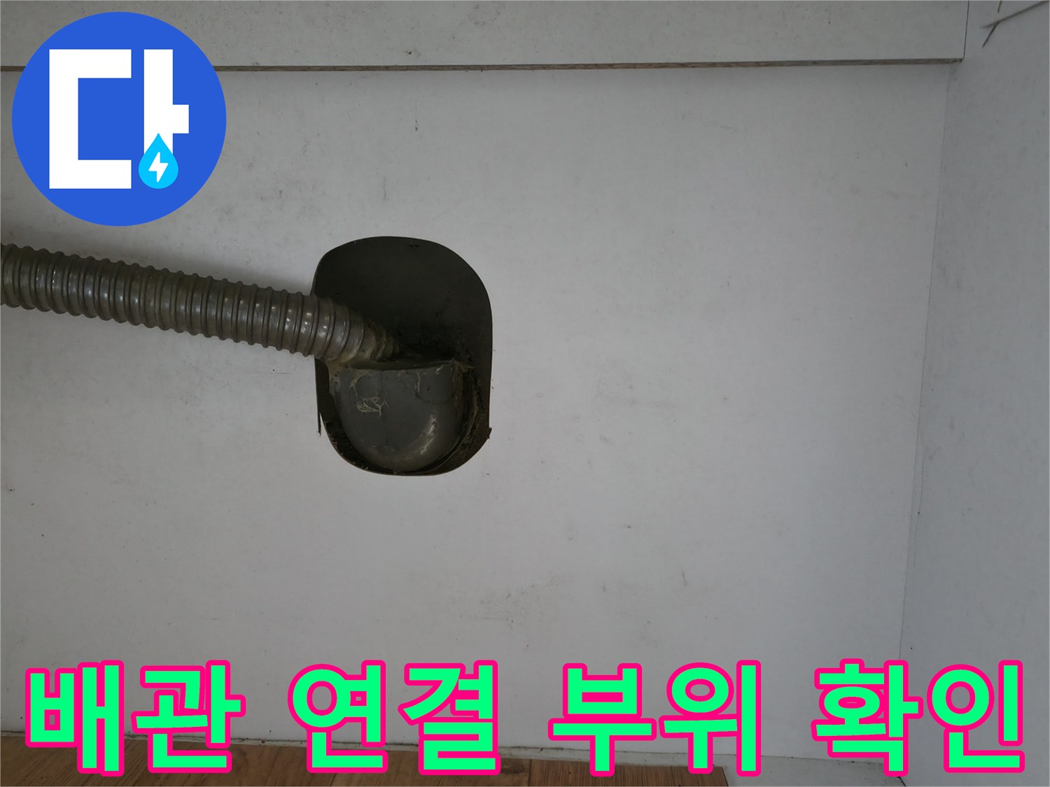 주방 하부장 내부의 주름관과 배수구 연결 상태를 촬영한 사진입니다.