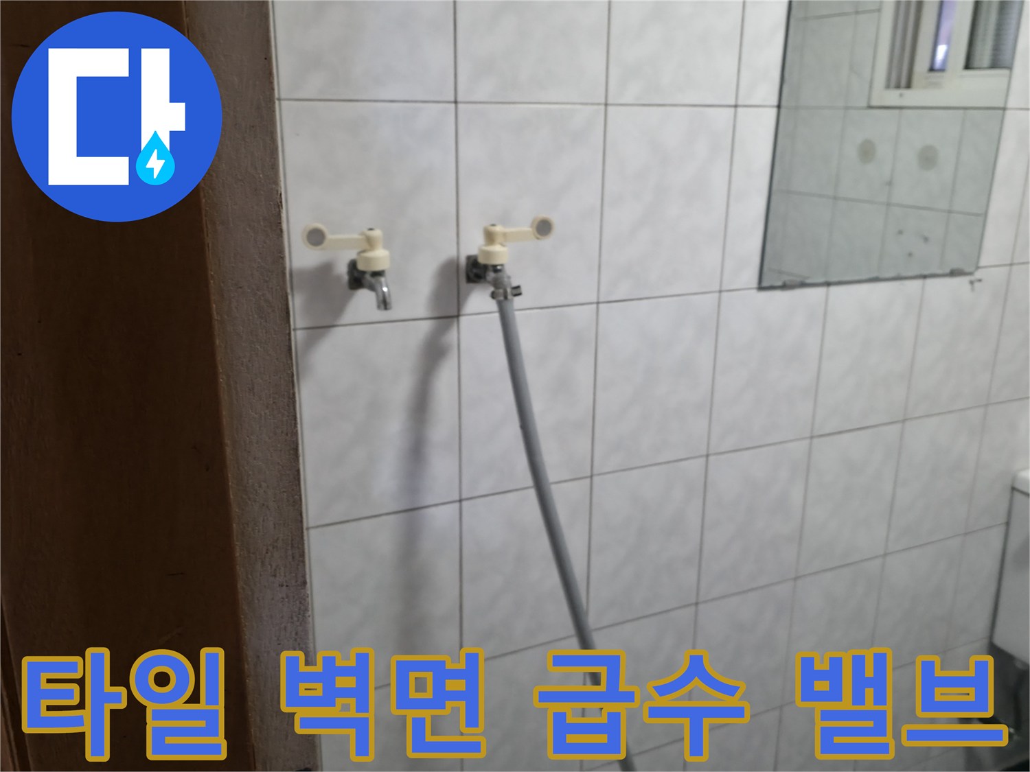 화장실 타일 벽면에 설치된-급수용 밸브와 연결 호스 부위