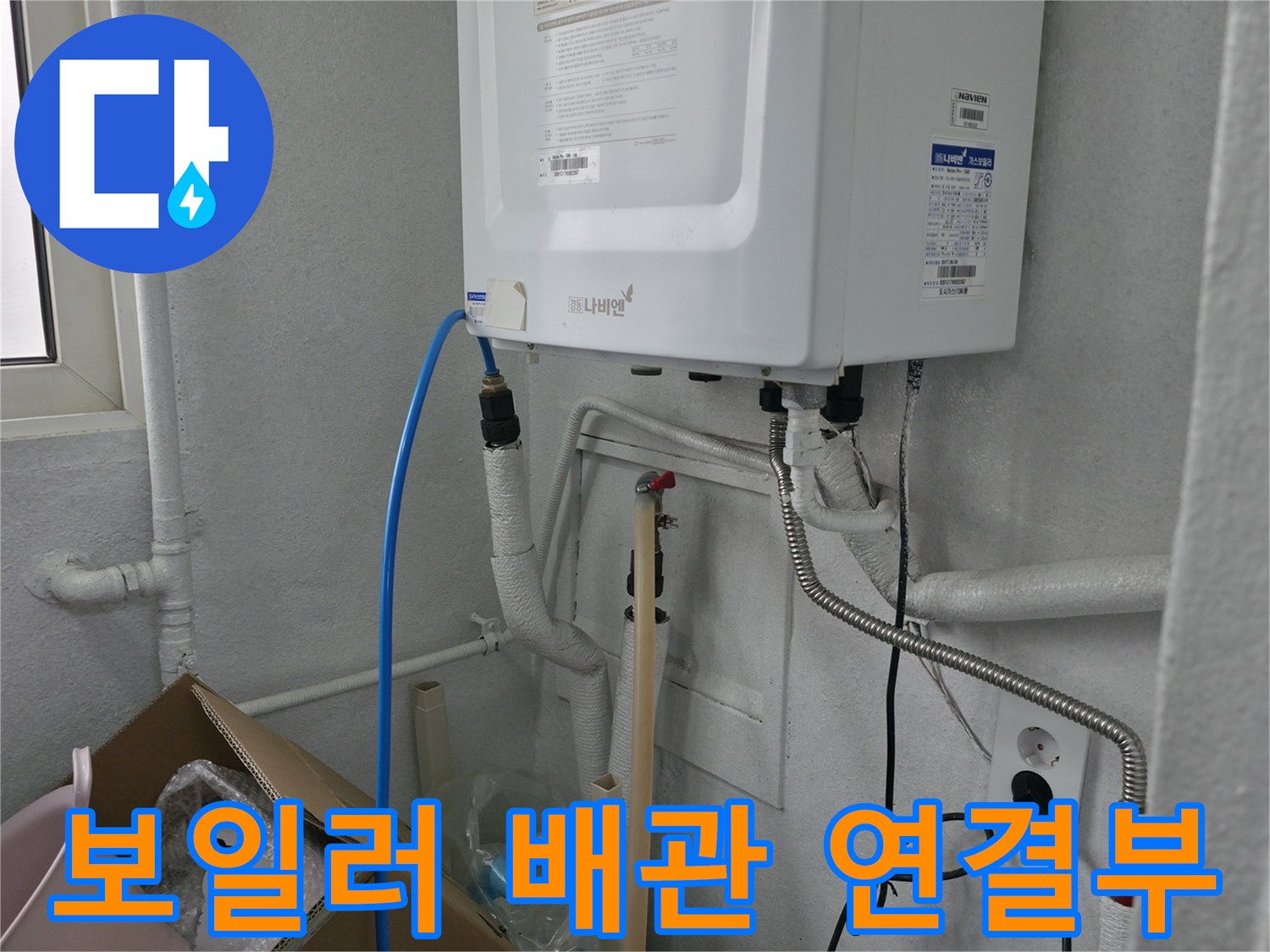 보일러 하단에 노출된 수도 배관과 전기 콘센트 주변 모습 - 배관 점검 중