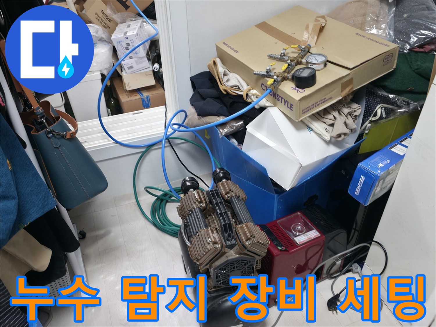 보일러실 바닥에 놓인 누수 탐지용 에어 컴프레서와 각종 배관 부속품들