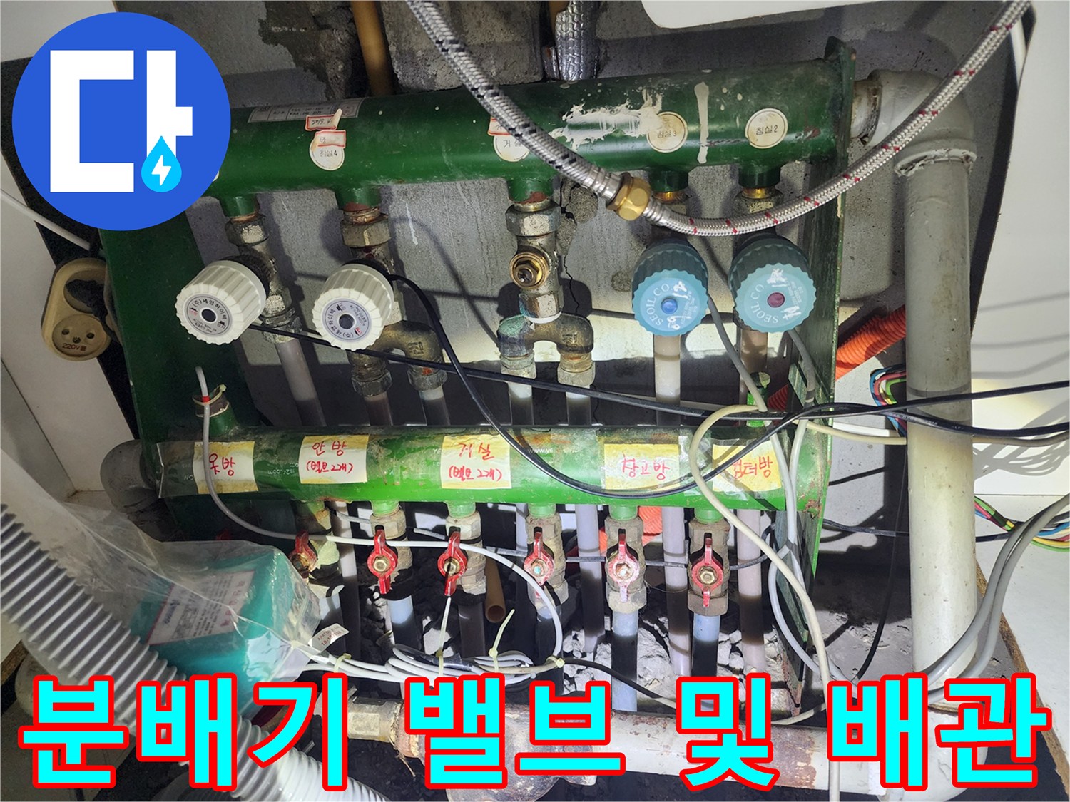 난방 분배기의 녹색 배관과 흰색 밸브가 연결된 상세 점검 사진입니다.