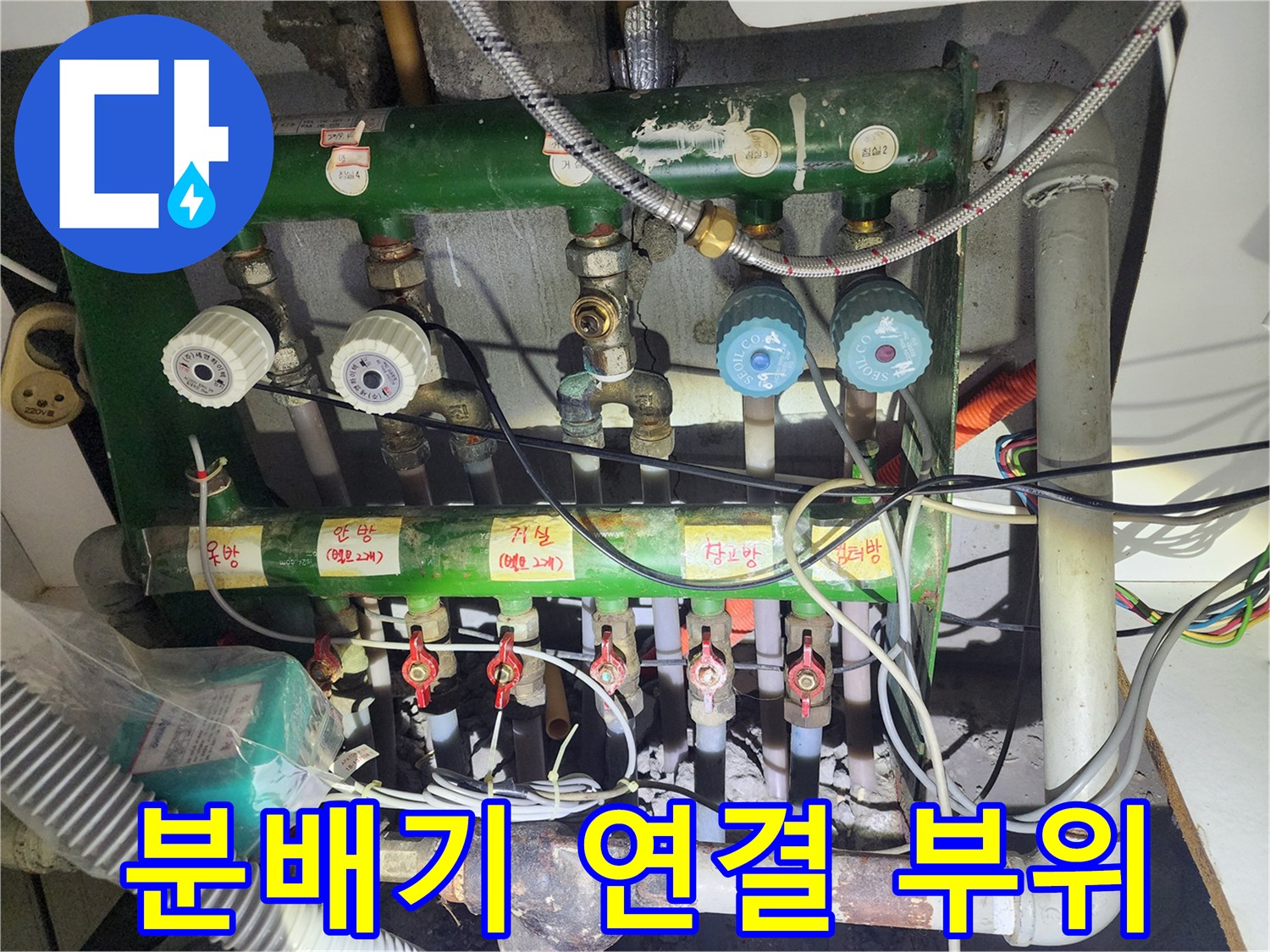 복잡하게 연결된 녹색 난방 분배기와 하단 배관 상세