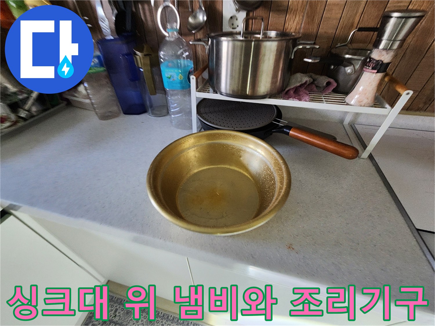 주방 싱크대 위에 놓인 스테인로 냄비와 금색 볼 사진