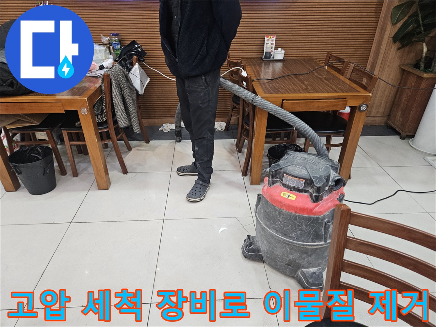 강력한 흡입력을 가진 석션기 장비를 이용해 하수관 내 오물을 제거하는 장면