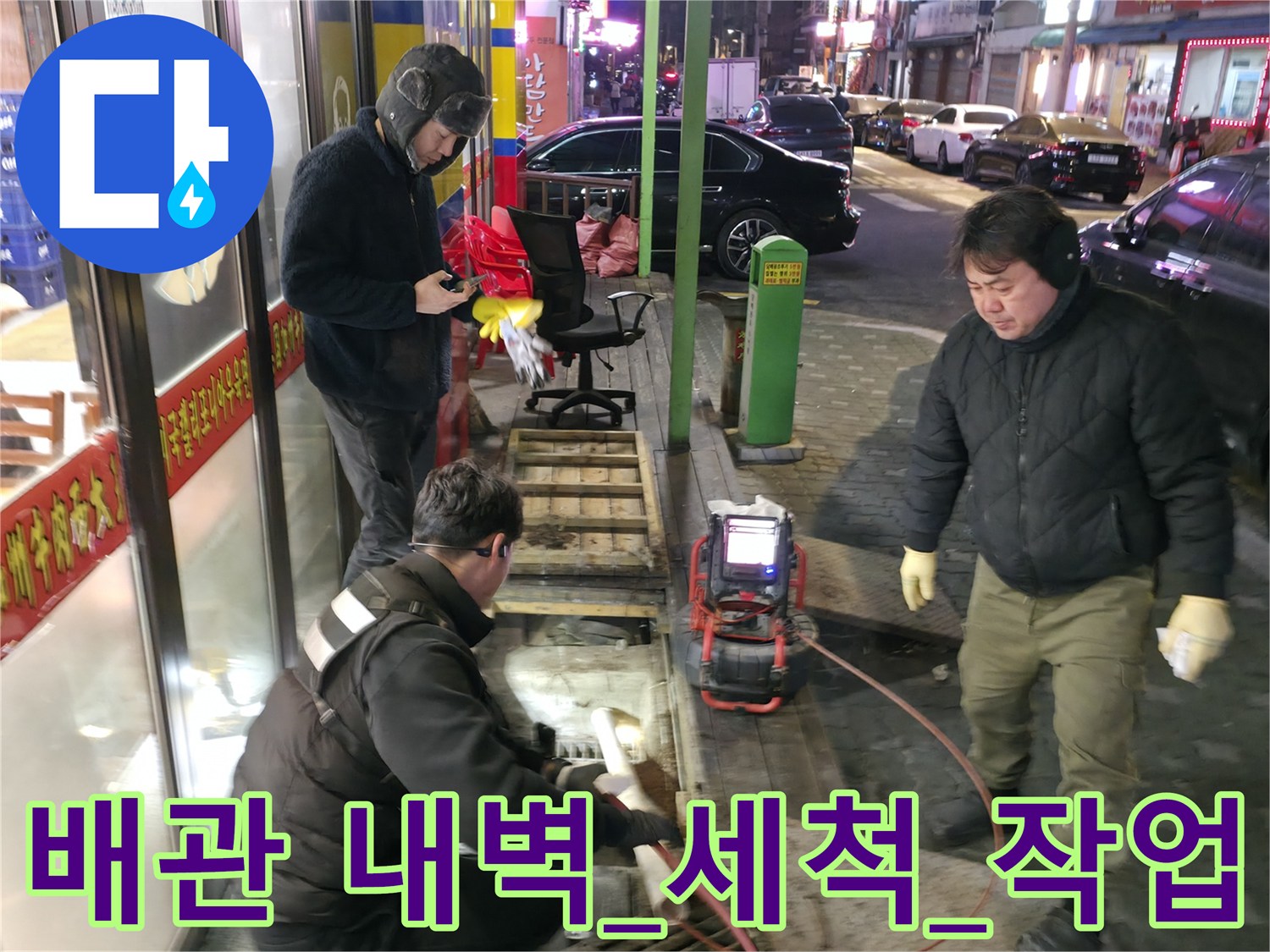 고압 세척기용_호스를_연결하여_메인_하수구의_슬러지를_제거하는_장면